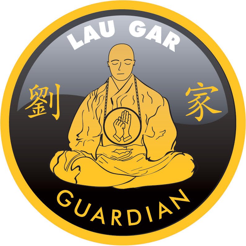 A circular emblem featuring a meditating monk in yellow robes with a hand symbol on his chest, set against a gradient black background. The top of the emblem has the words 'LAU GAR', and the bottom has 'GUARDIAN'. Two Chinese characters are on either side of the monk.