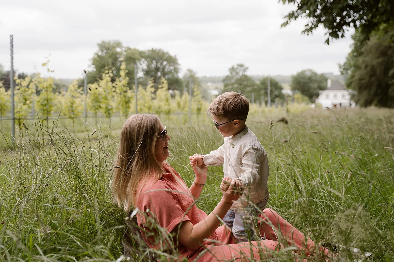 Een kind met myopie die met zijn moeder speelt in het hoge gras op de Utrechtse Heuvelrug.