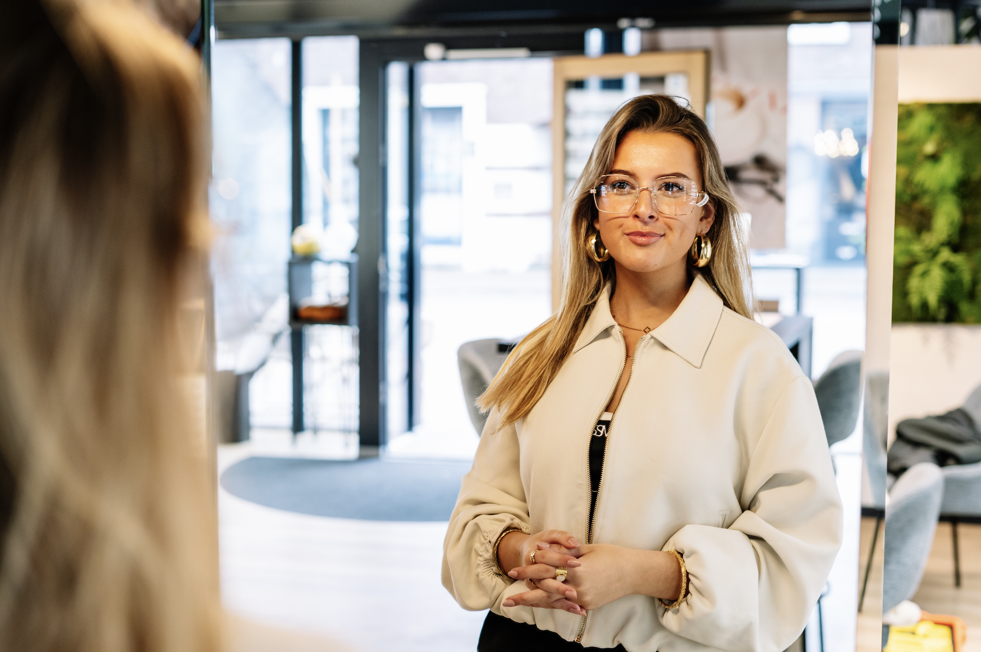 Jonge vrouw die een bril past bij opticien House of Glasses. 