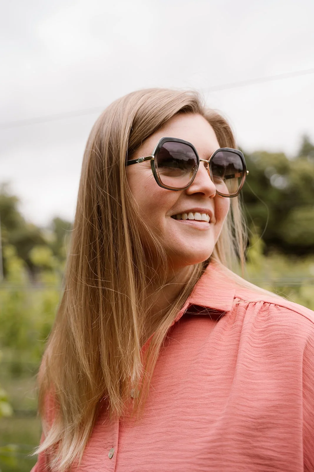 Vrouw met zonnebril in een wijngaard.
