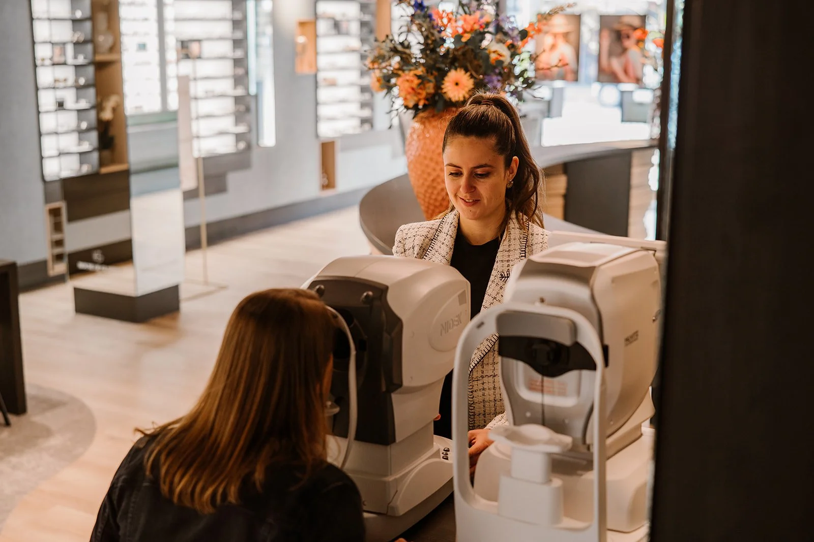 Een opticien voert een oogmeting uit bij een vrouw.