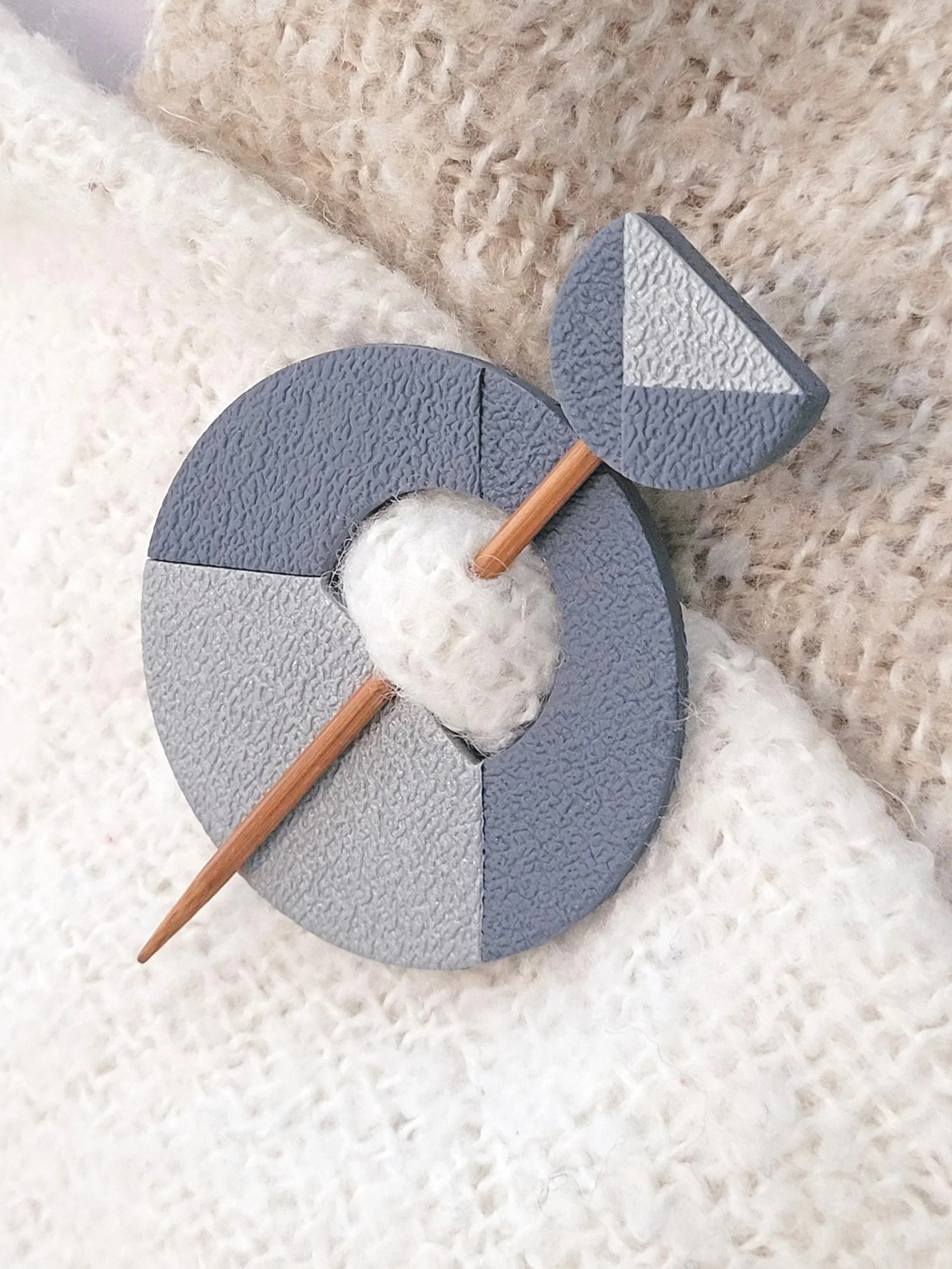 The decorative grey pin head features a geometric half circle with a metallic silver triangular accent.