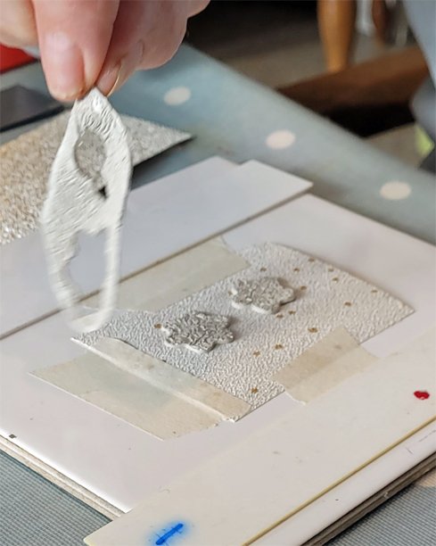 Removing a piece of scrap clay whilst making a pair of earrings.