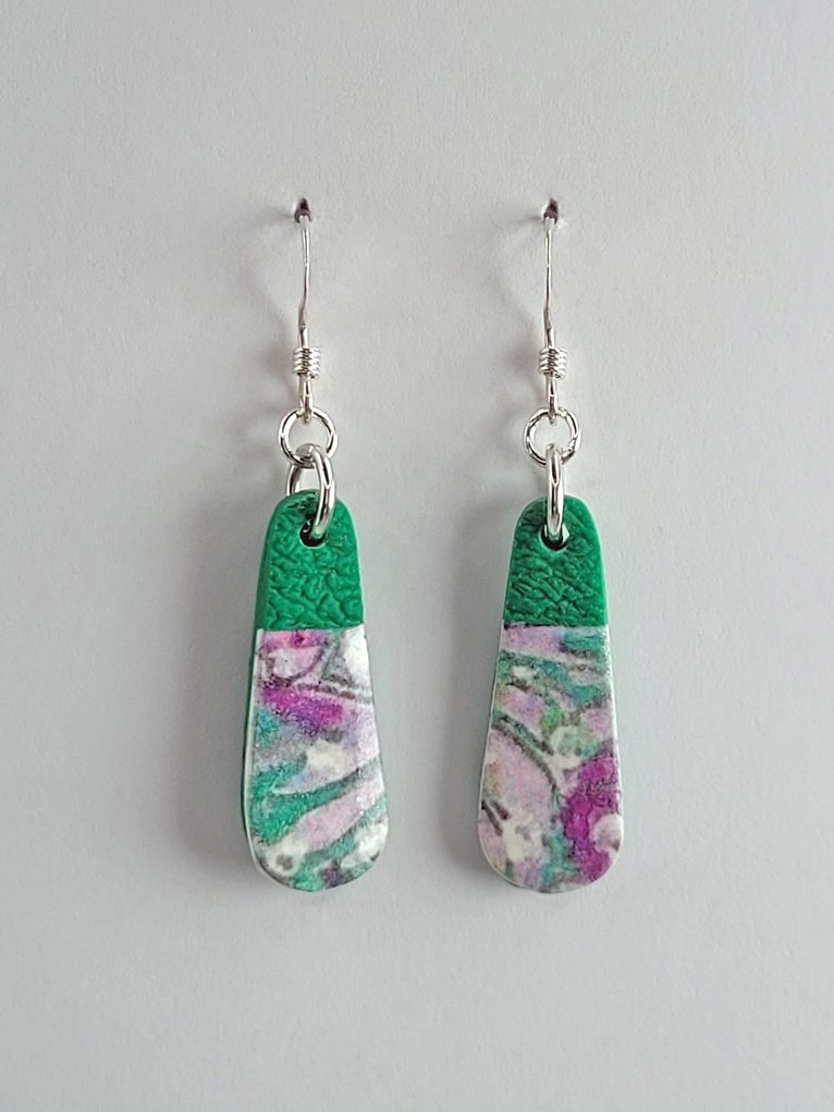 Small droplet-shaped earrings with a different placement of pastel floral design in pink, purple, white, soft grey and green, shown face-on with sterling silver hooks.