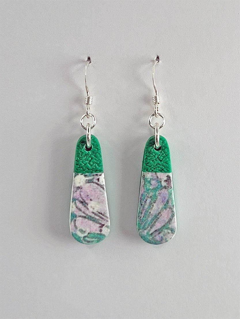Small droplet-shaped earrings with an alternative pattern composition of pastel floral design in mauve, white, soft grey, green and with less pink, shown face-on with sterling silver hooks.