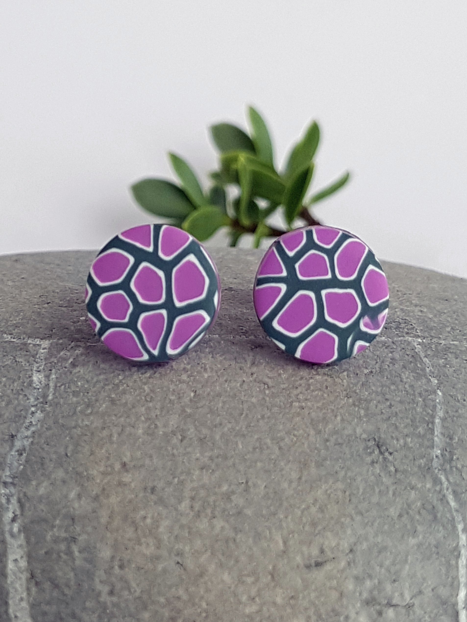 Handcrafted polymer clay stud earrings with a finely detailed abstract geometric pattern in lilac, white and grey.
