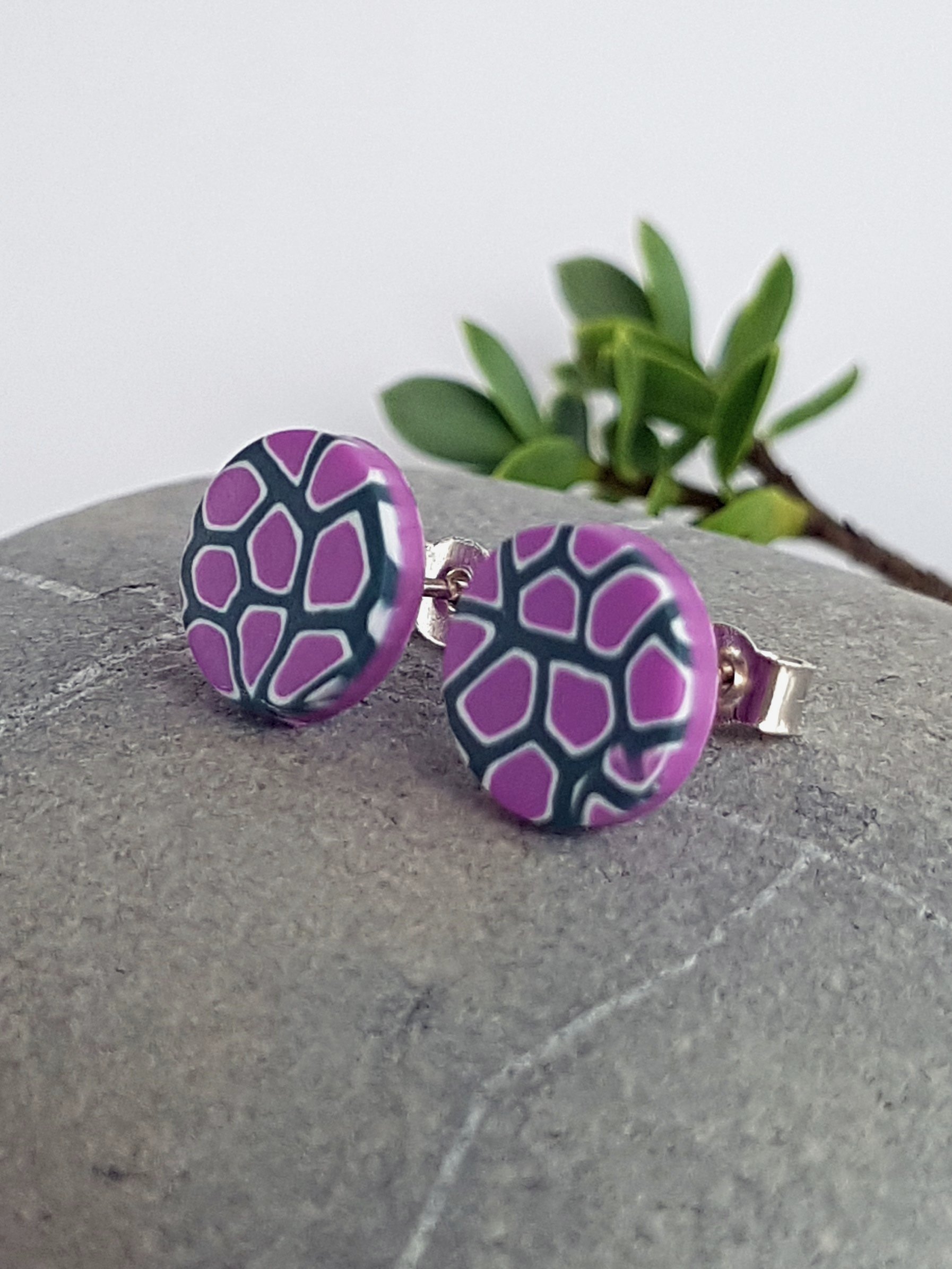 10 mm, lightweight stud earrings with a geometric pattern in lilac, white and grey with a smooth, matte surface.