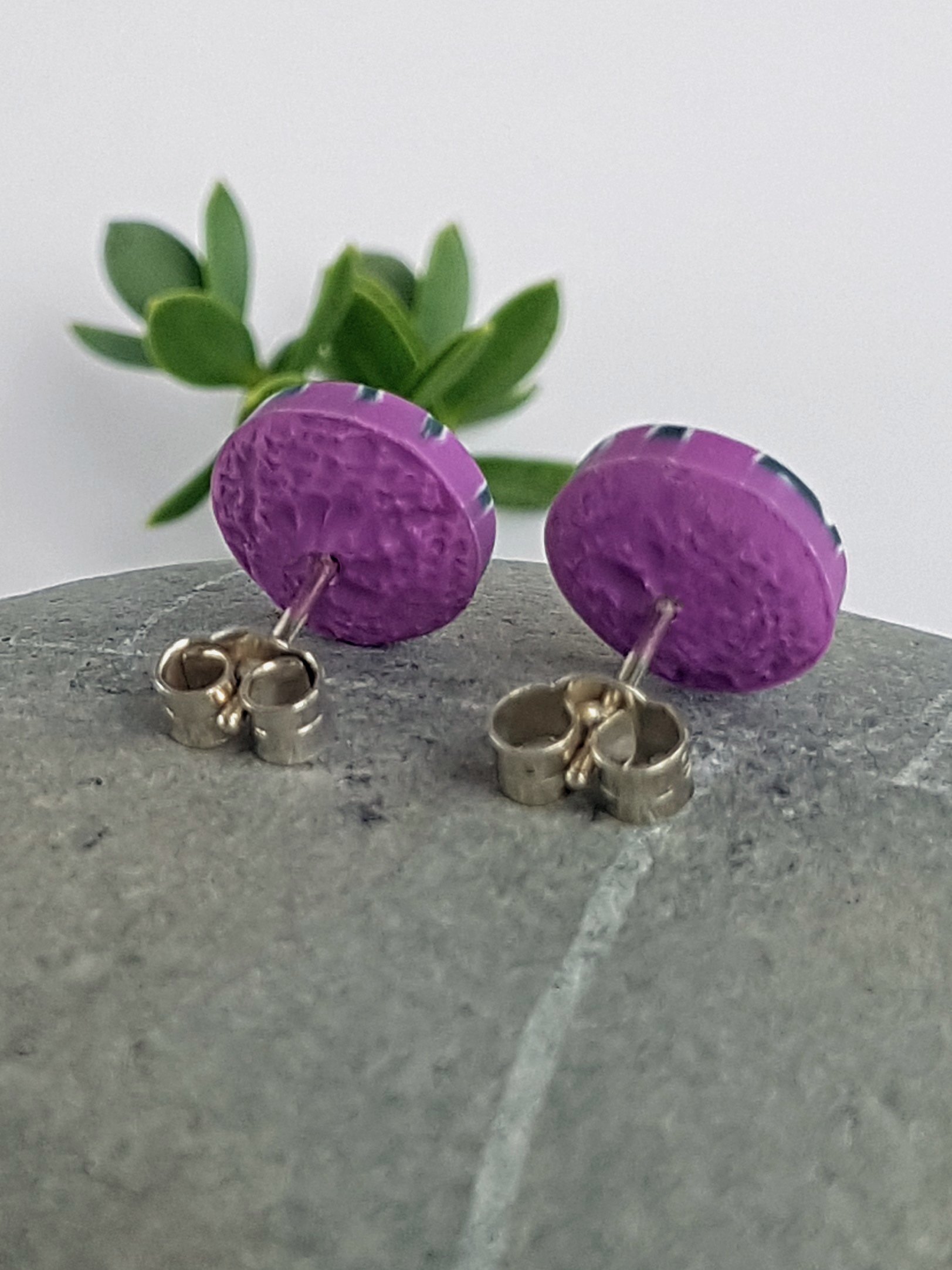 Stud earrings with lightly textured lilac clay backs, sterling silver posts and scrolls to wear on the ear lobe.