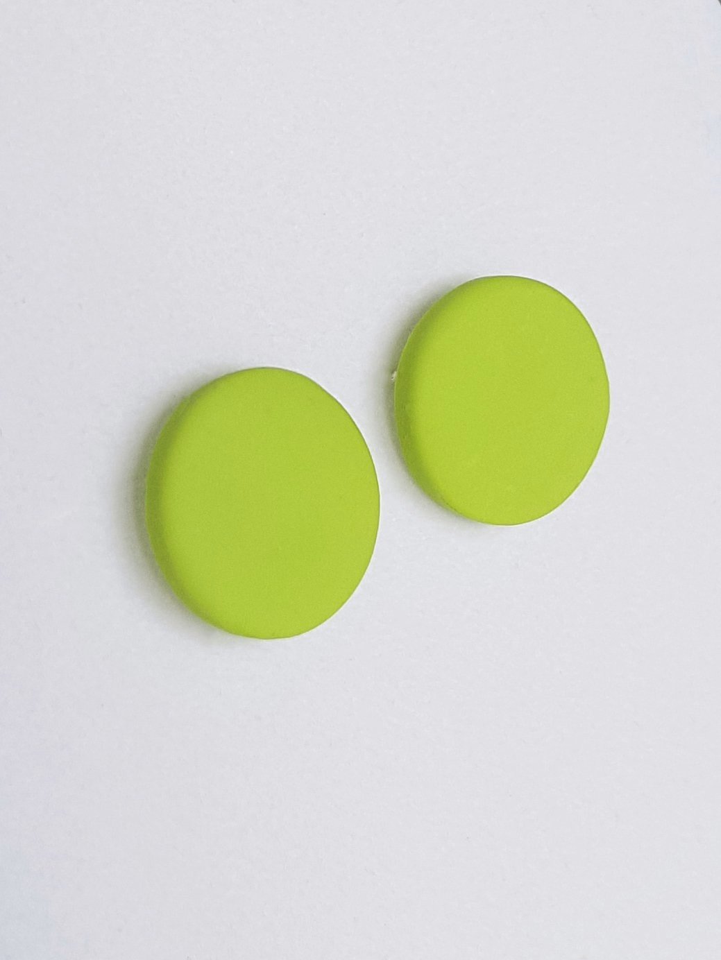 Lime green round stud earrings with a smooth matte finish made with polymer clay and sterling silver posts and scrolls.