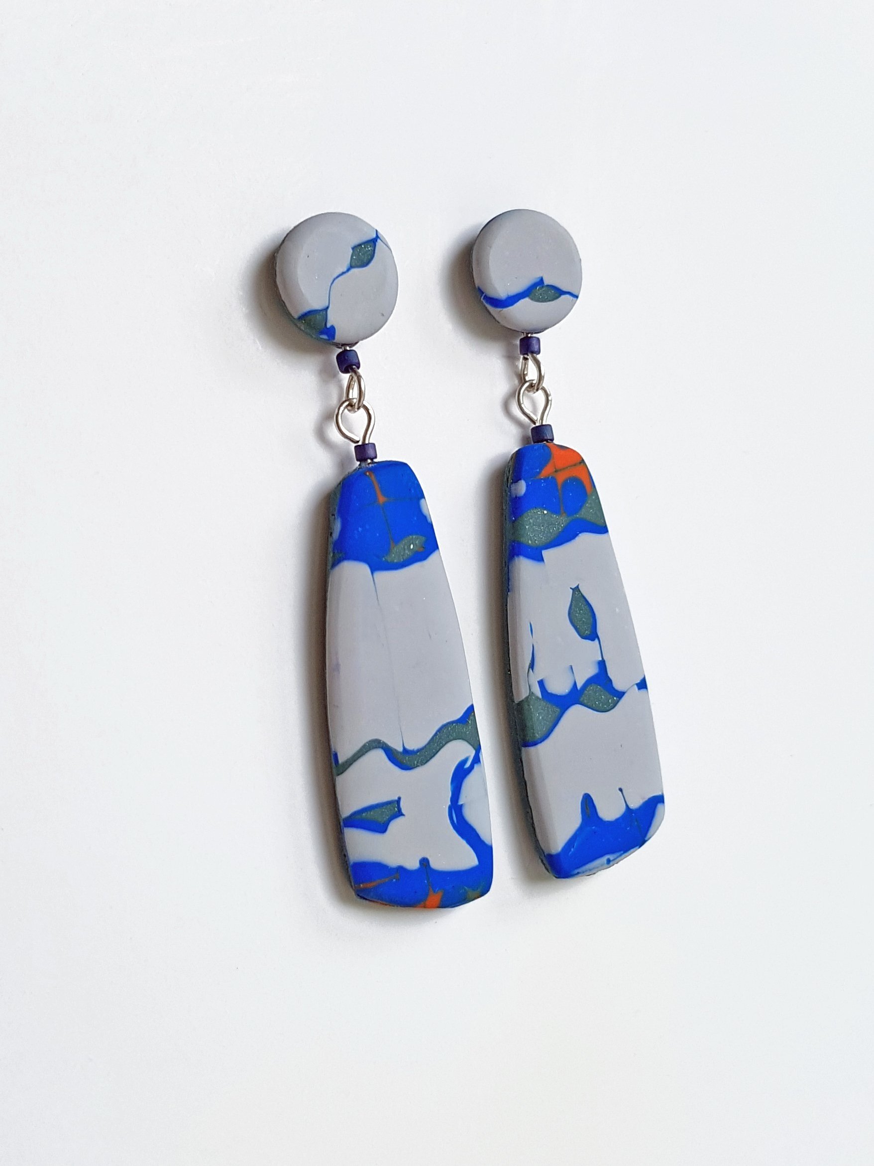 Subtle variations in the abstract pattern exist between Frequency Grey earrings.