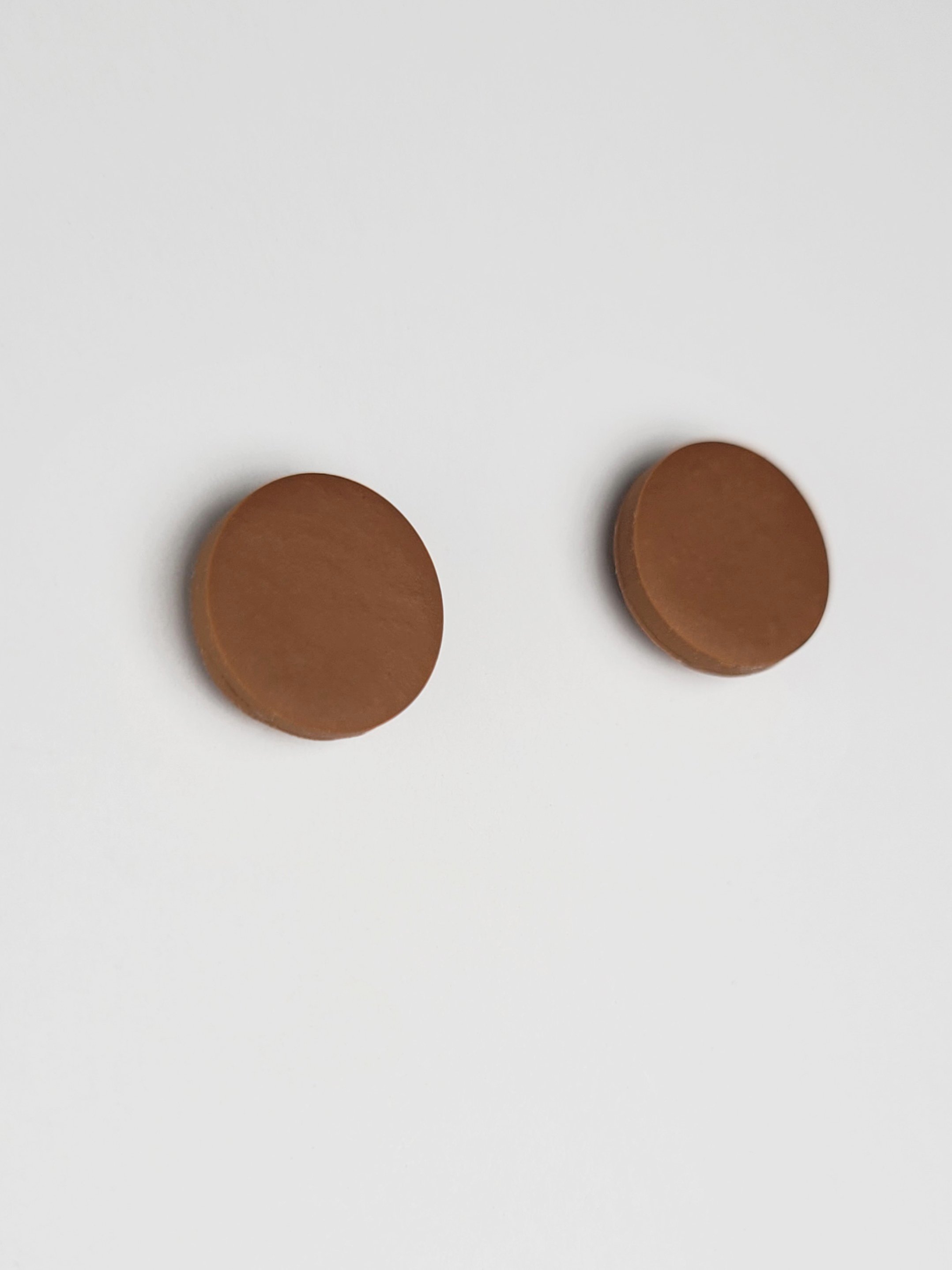 Nut brown round stud earrings with a smooth matte finish made with polymer clay and sterling silver posts and scrolls.