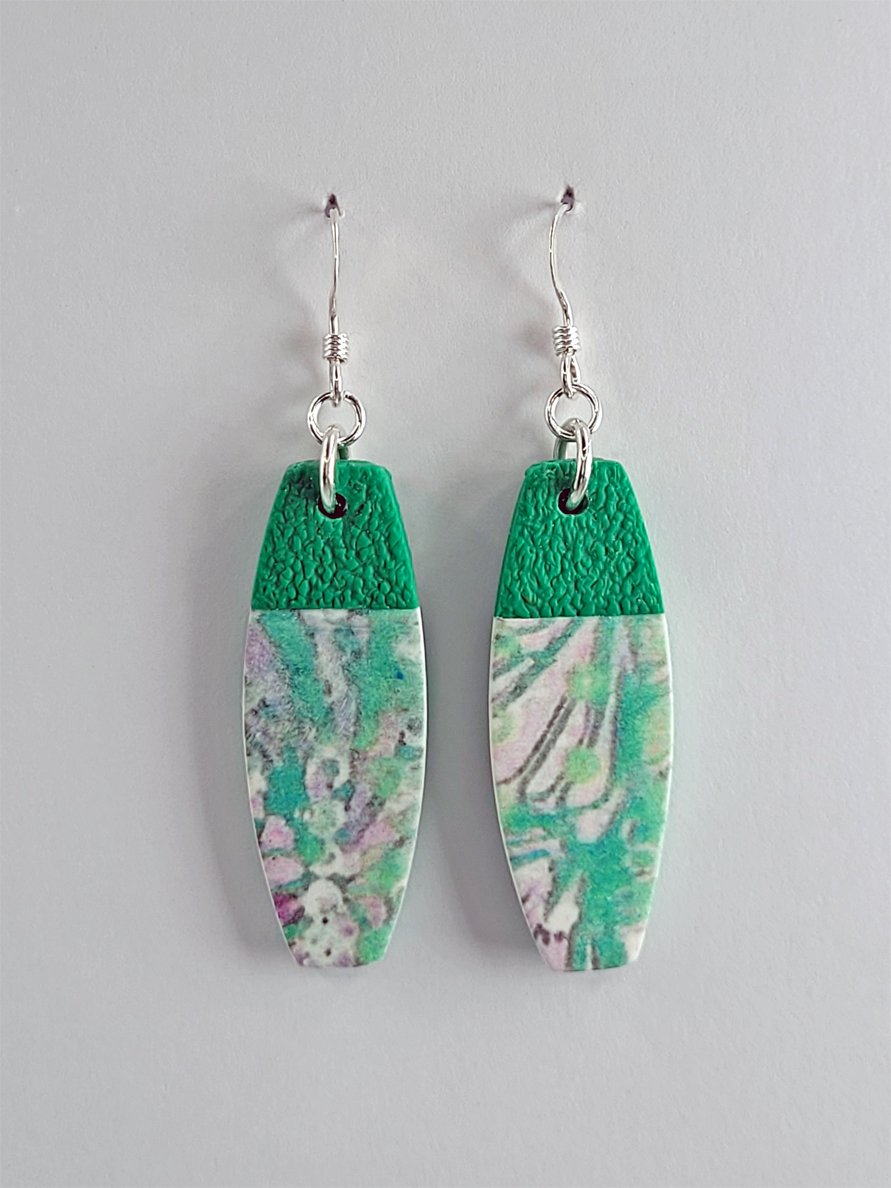 Option 2, rectangular drop earrings with convex long edges, pastel floral design in green, white, and grey, with less pink than option 1 shown face-on with sterling silver hooks.