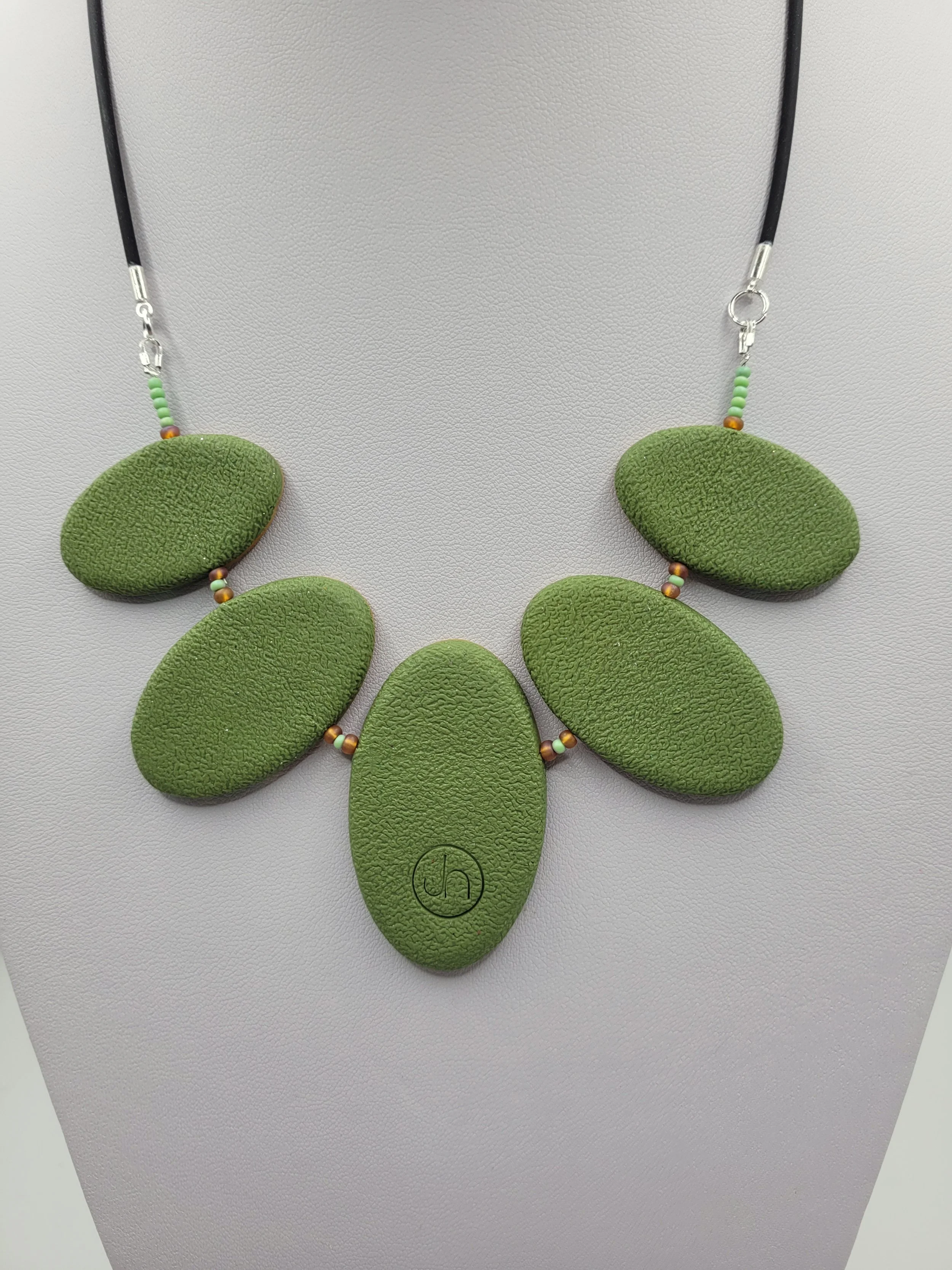 The back of the Green Ticker Tape necklace comprises textured olive green polymer clay.