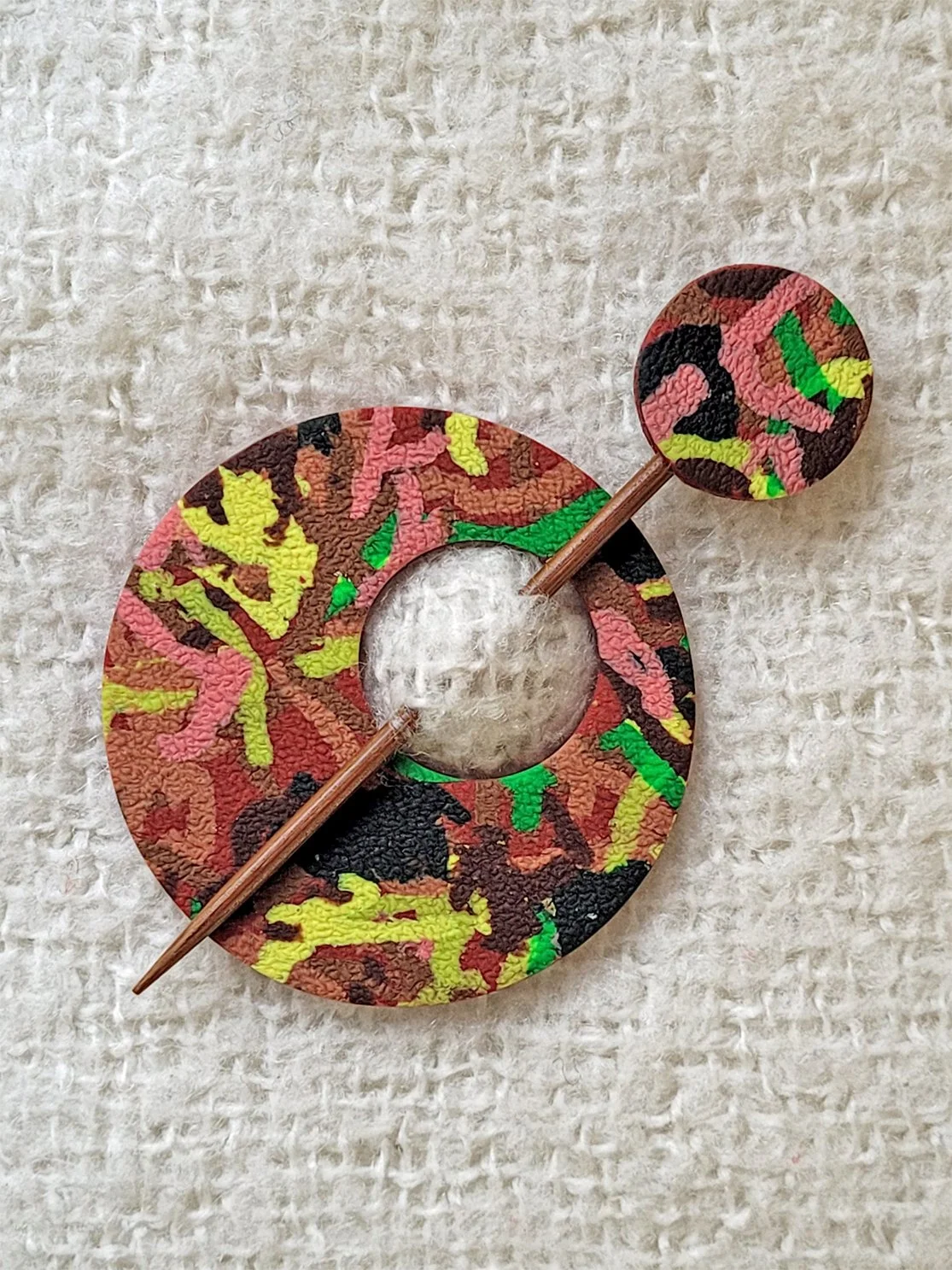 Flat lay image of Terracotta Ticker Tape polymer clay shawl pin, with a bamboo pin, topped with a matching round disc.