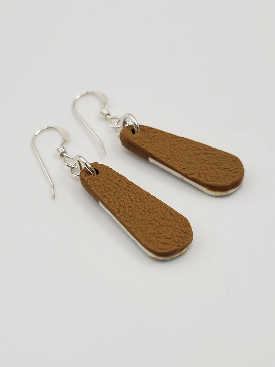 Back view of droplet earrings with ginger textured polymer clay and sterling silver earwires.