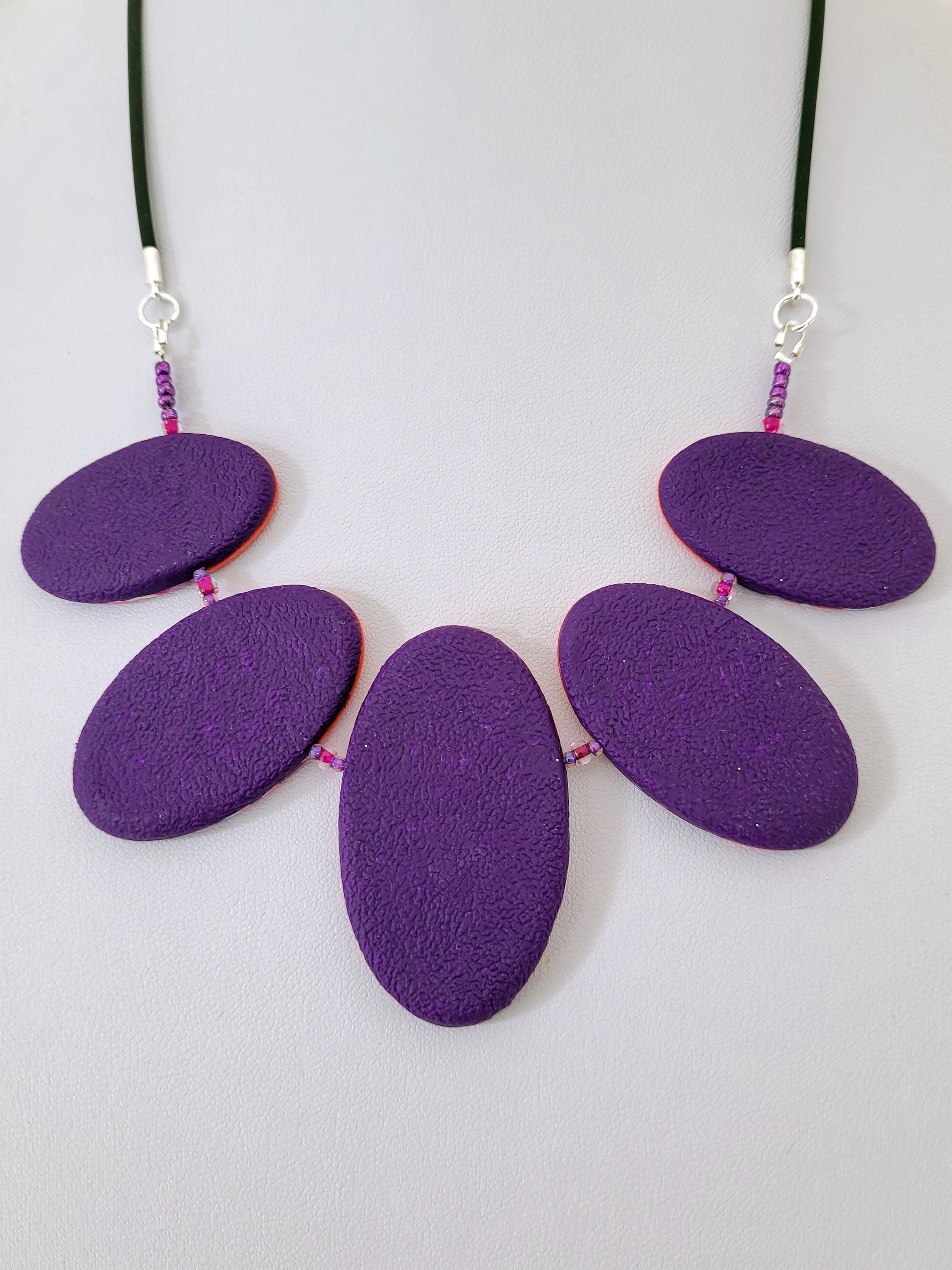 The back of the Purple Ticker Tape Necklace comprises textured purple polymer clay.