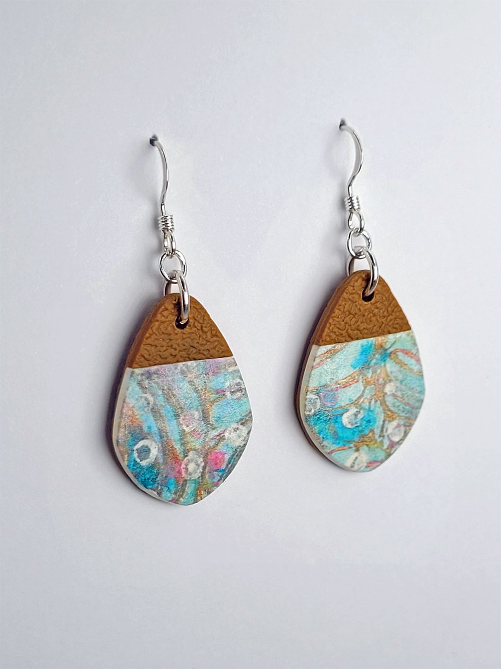 Side view of 'fat' Sprig Ginger teardrop earrings with softly pointed tips, showcasing their smooth floral finish and textured details.