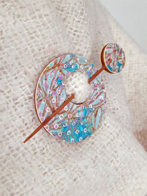 Edge of pin, highlighting the decorative abstract foliage pattern and contrasting ginger brown polymer clay back.