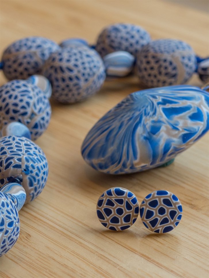 a necklace with assorted bead shapes decorated with a millefiori cane in navy, grey and white.