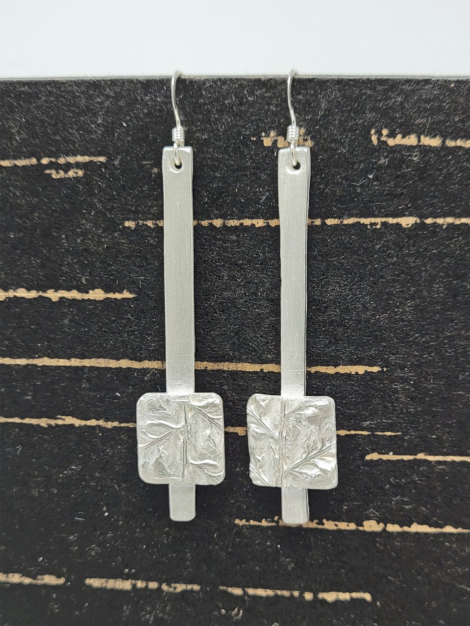 Katie made long thin dangle earrings decorated with square embossed panels on a Silver Clay Jewellery for Beginners class.