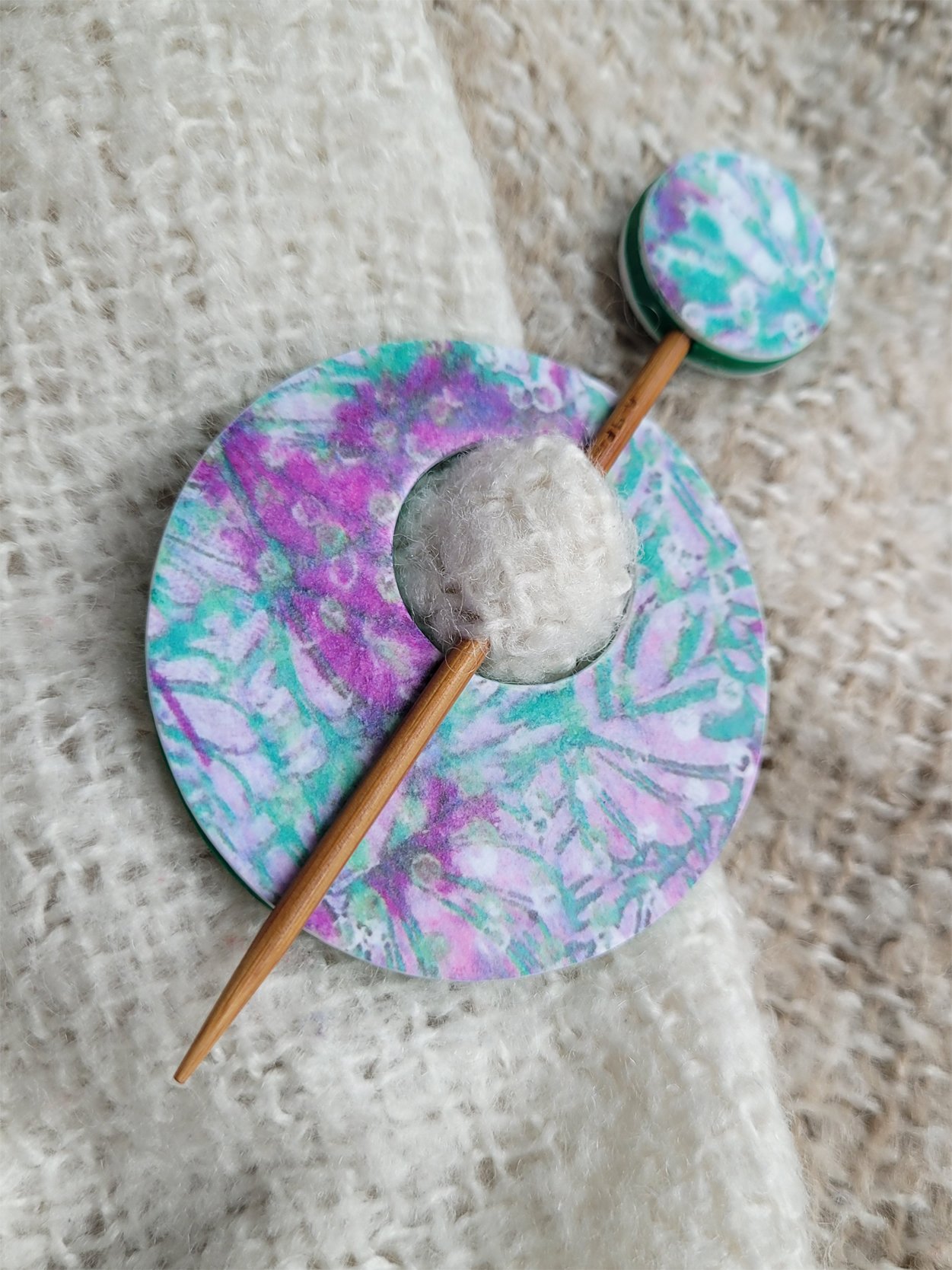 Edge of pin, highlighting the decorative abstract foliage pattern and contrasting green polymer clay back.