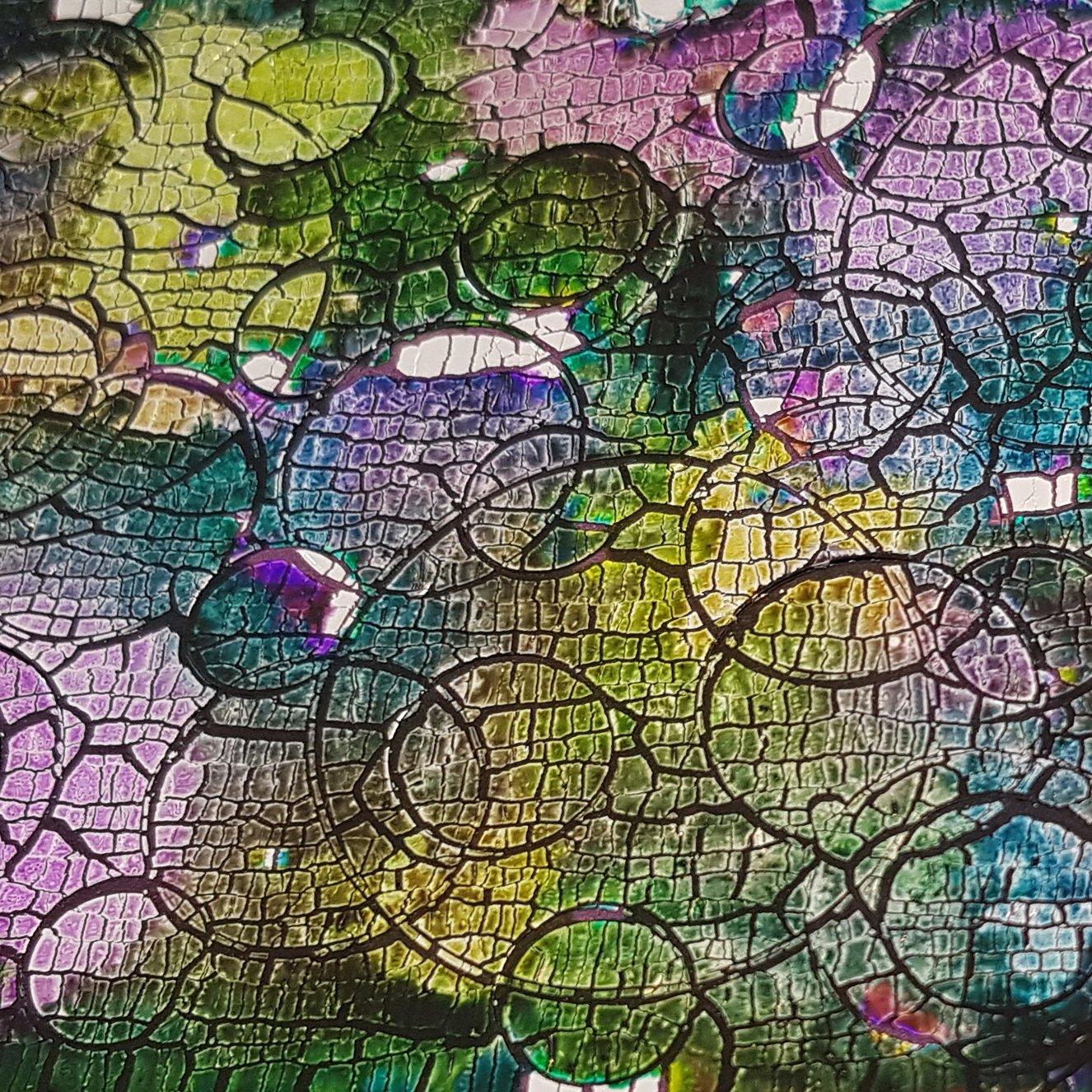 A detail of a shimmer and sparkle veneer in greens and purples.