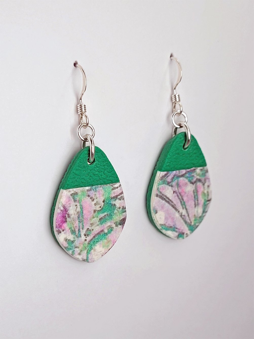 Side view of 'fat' teardrop earrings with softly pointed tips, showcasing their smooth floral finish and textured details.