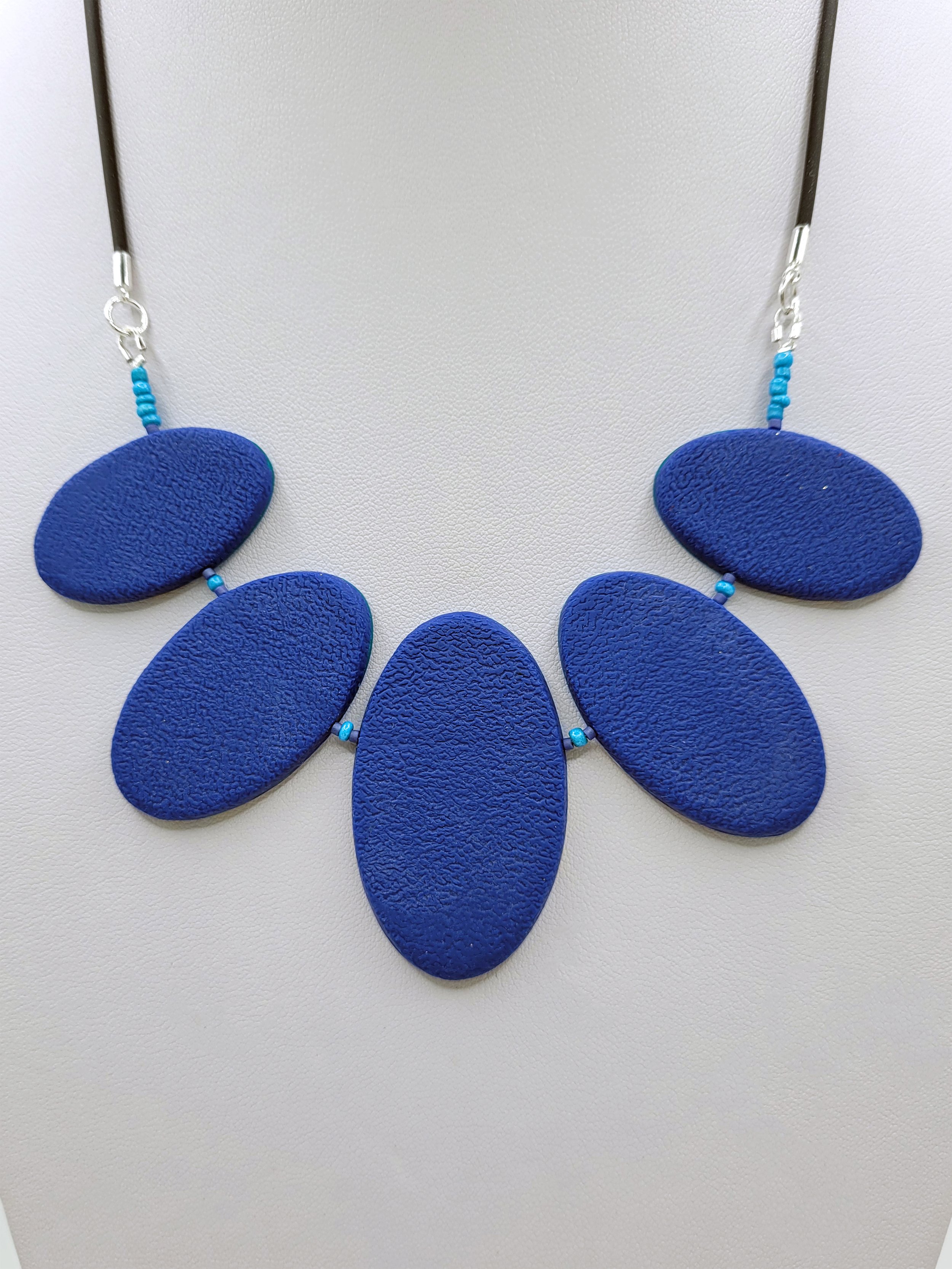 The back of the Blue Ticker Tape Necklace comprises textured navy polymer clay.