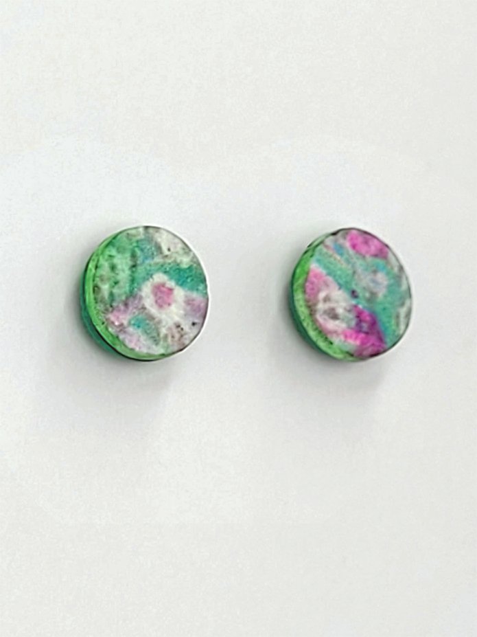 Stud earrings with green, pink and white faces and irregular green edges.