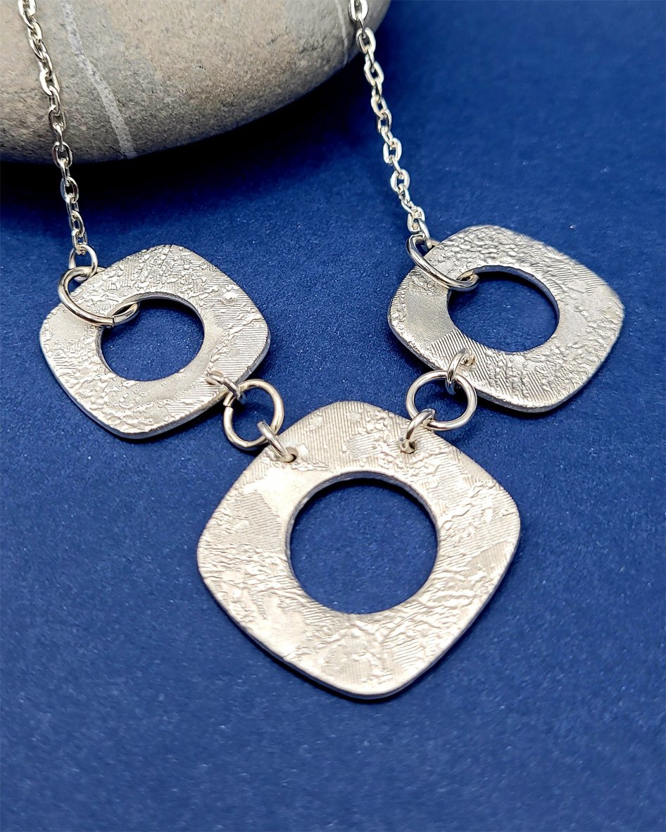 A 3 square bead fine silver necklace with round cutouts made by Linda.