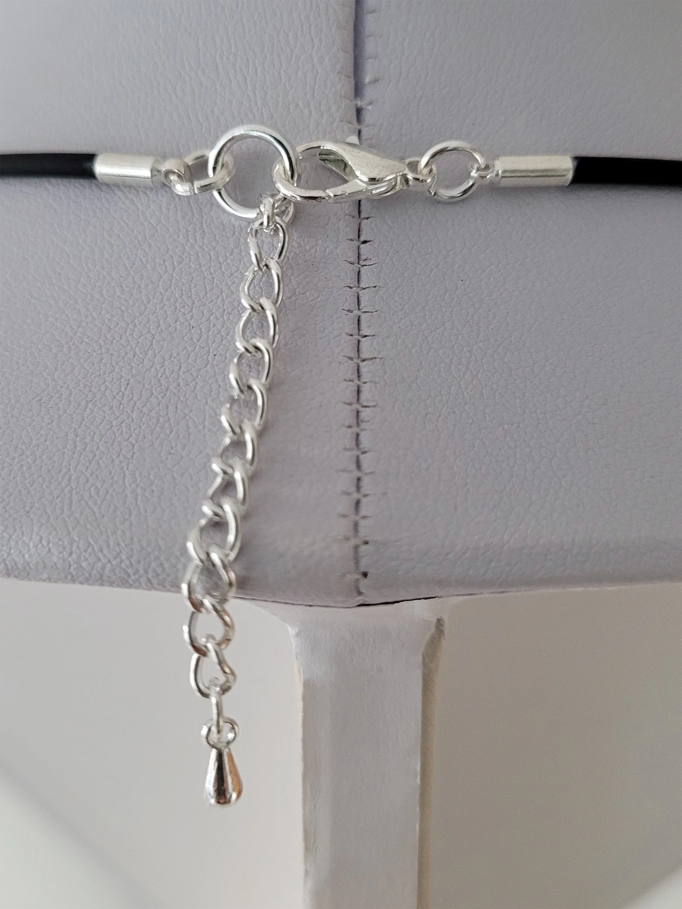 The Ticker Tape Necklace silver plate lobster clasp and rubber cord in detail.