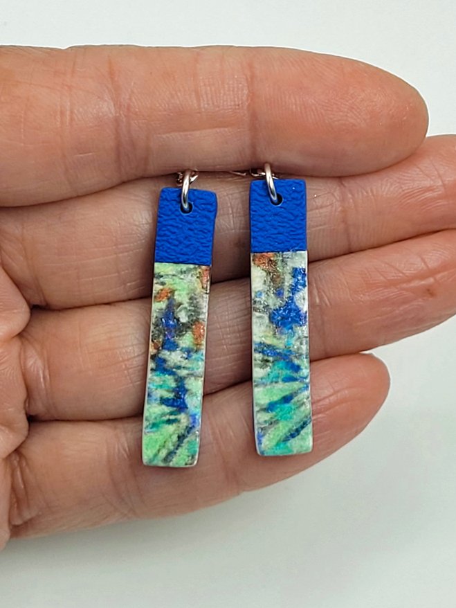 Sprig Blue Cane long rectangular earrings held in a hand, illustrating their size and pattern detailing.