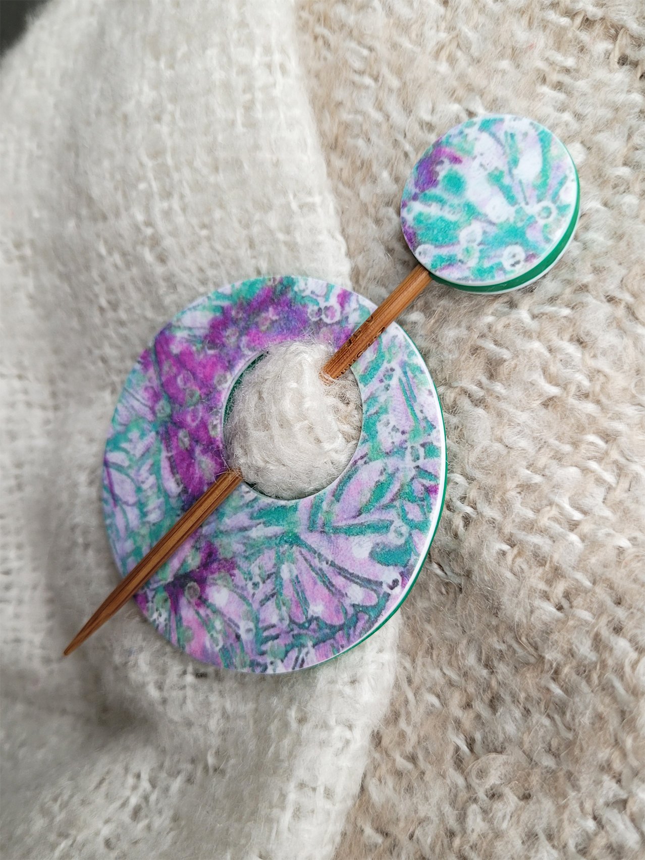 Contemporary, round disc and pin shawl fastener in shades of green, pink, mauve and grey.