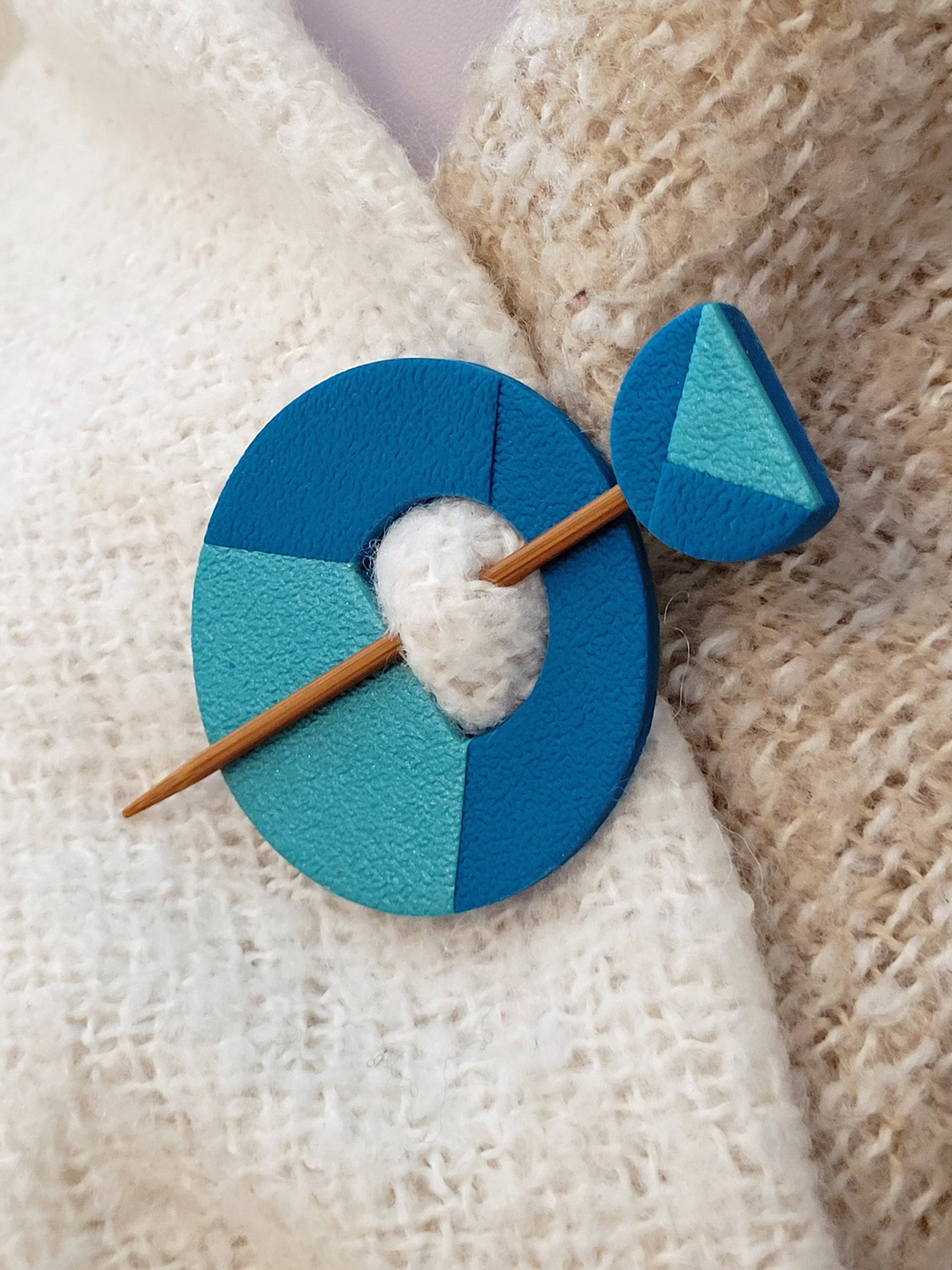 The decorative teal pin head features a geometric blue green half circle with a pearlescent turquoise triangular accent.