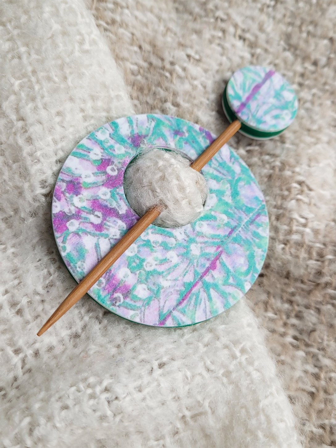 Edge of pin, highlighting the decorative abstract foliage pattern and striking leaf green polymer clay back.