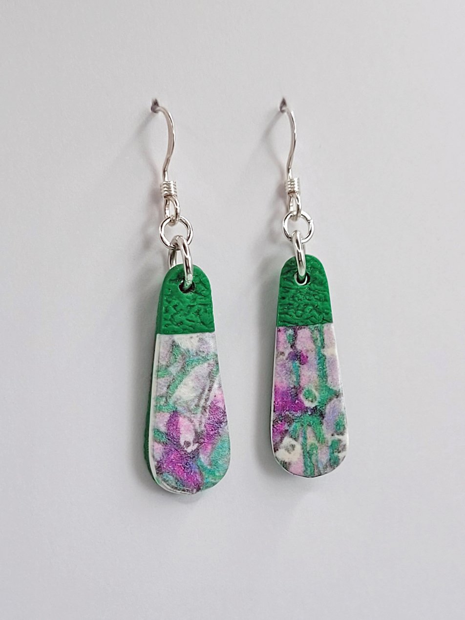 Side view of droplet-shaped earrings showing the soft abstract floral pattern with satin finish and contrasting matte green accents.