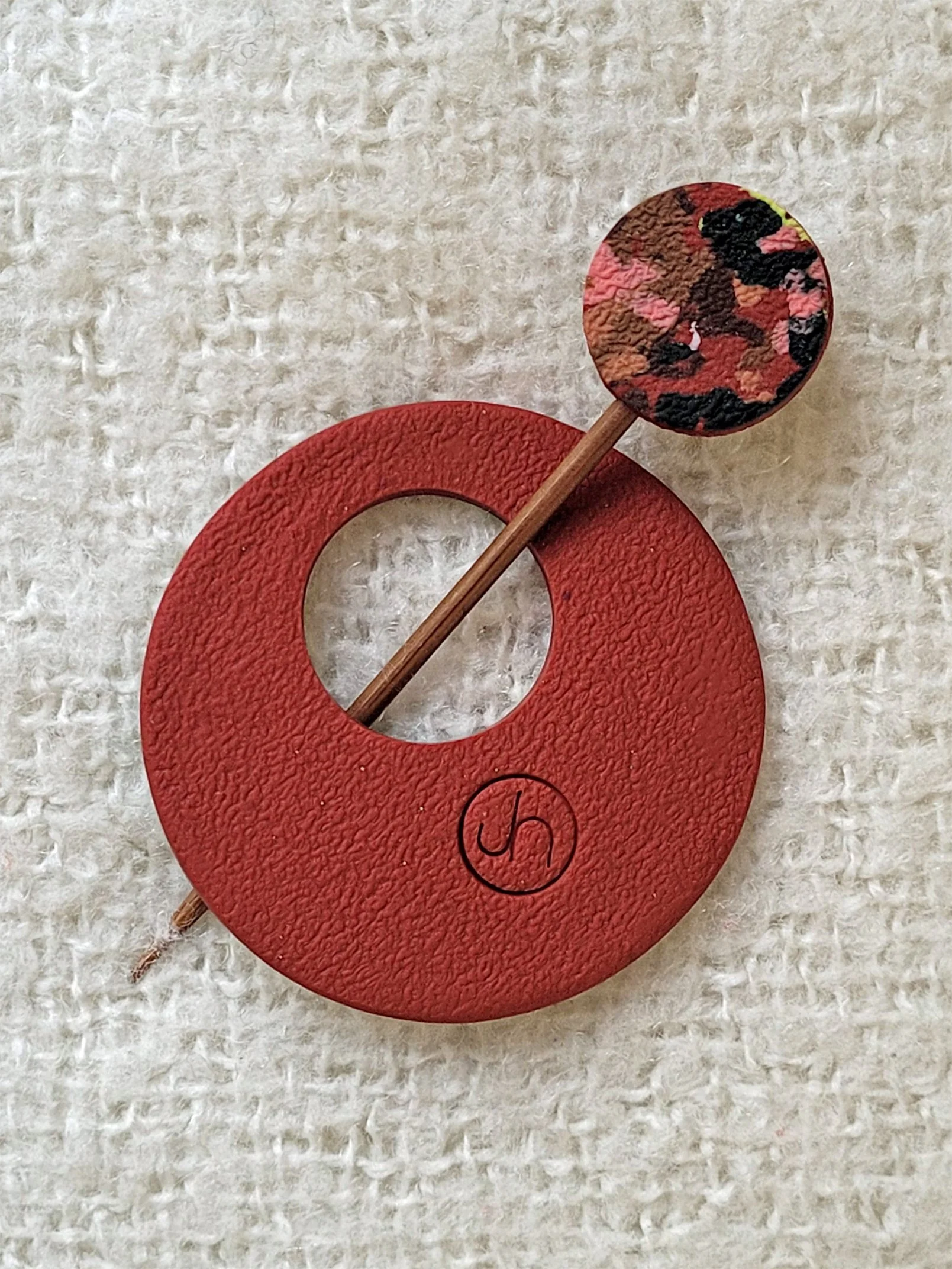 Textured dark terracotta back of Terracotta Ticker Tape Pin, with colourful round top to the bamboo pin.
