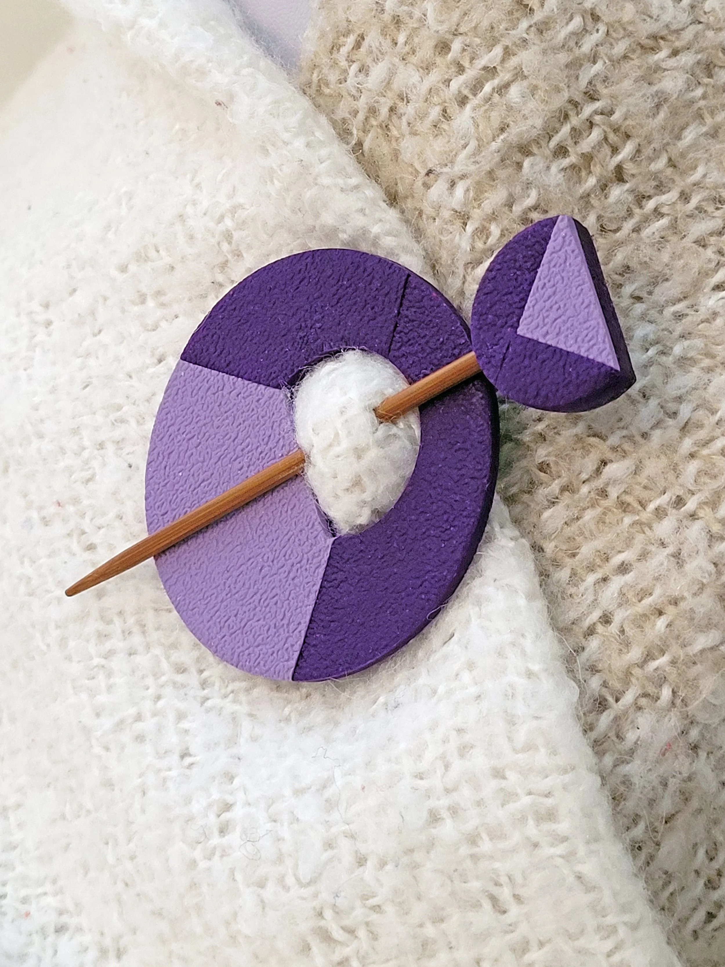 The decorative purple pin head features a violet geometric half circle with a pearlescent mauve triangular accent.