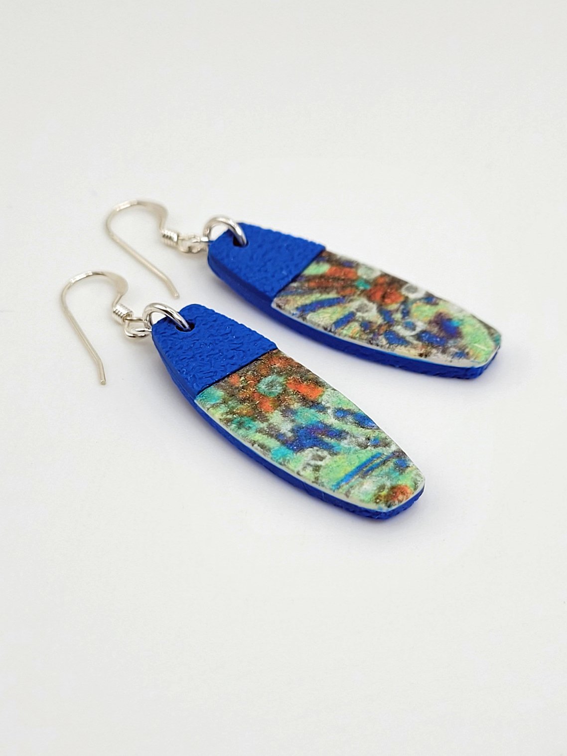 Flat lay of Sprig Blue tablet-shaped earrings highlighting their abstract pastel floral design and contemporary look.