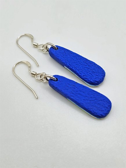Back view of droplet earrings with bright blue textured polymer clay and sterling silver earwires.