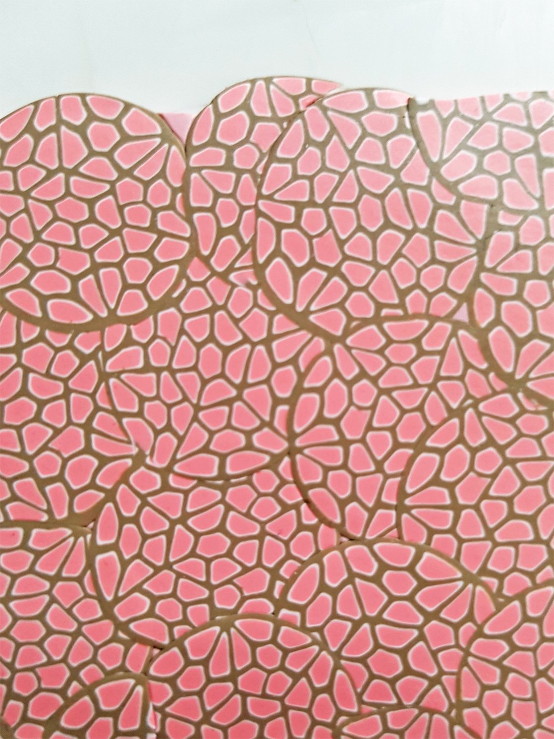 A series of pale pink and beige cane slices burnished flat to create a veneer