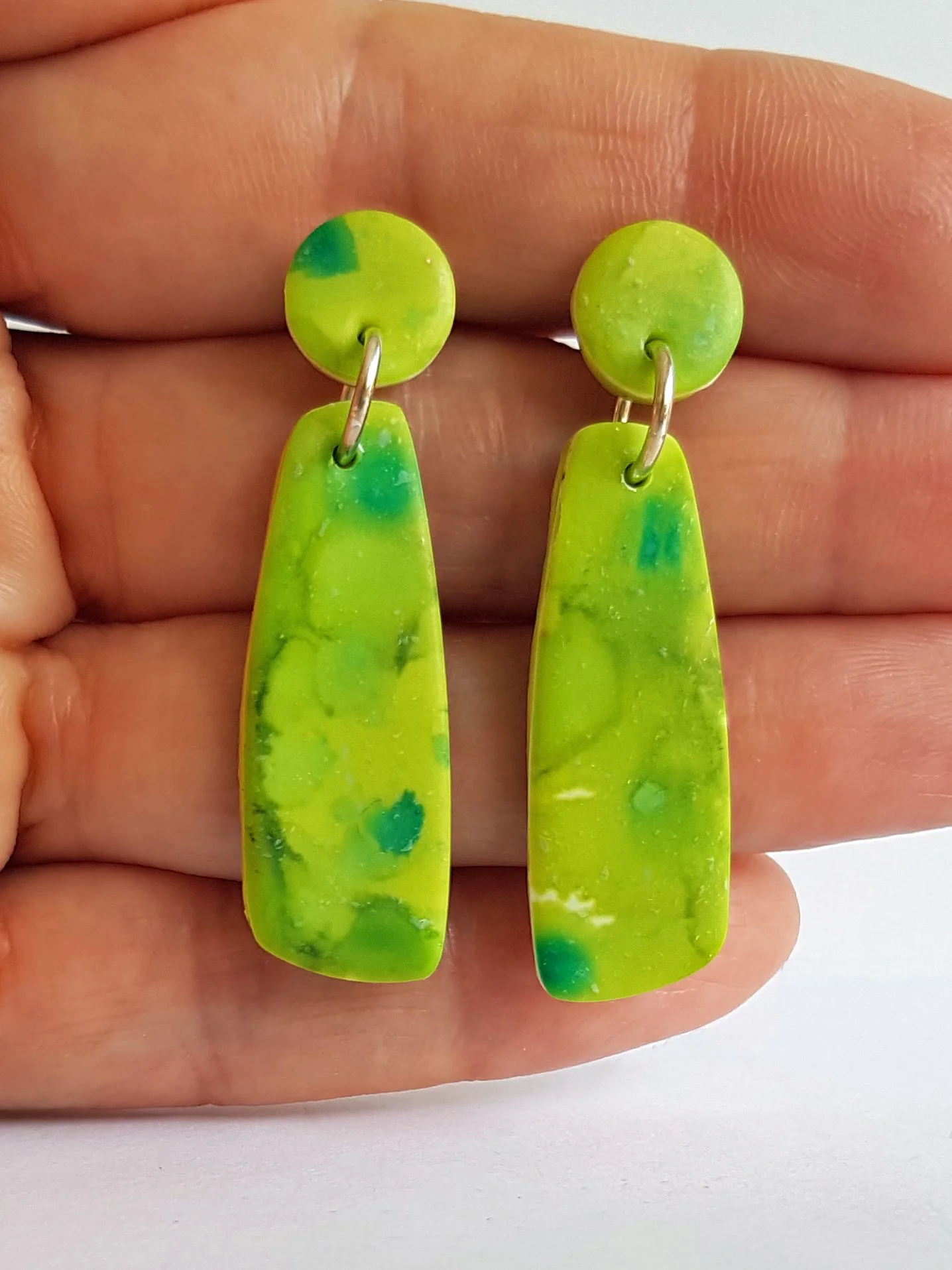 Lime green polymer clay earrings held.jpg