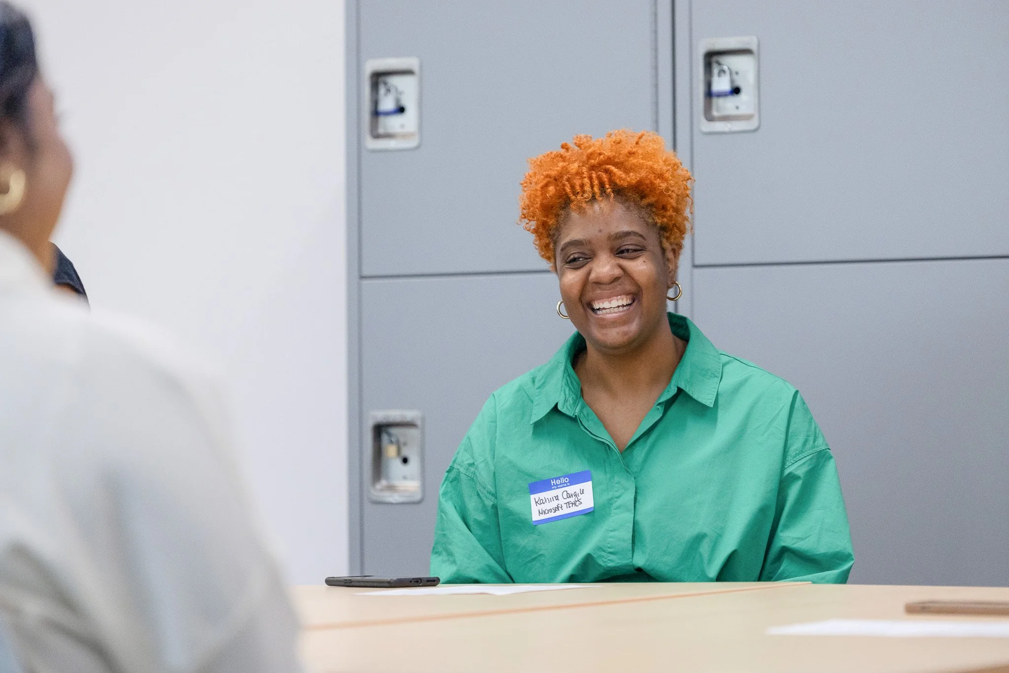 A workshop participant laughs mid-conversation at a Milwaukee nonprofit program.