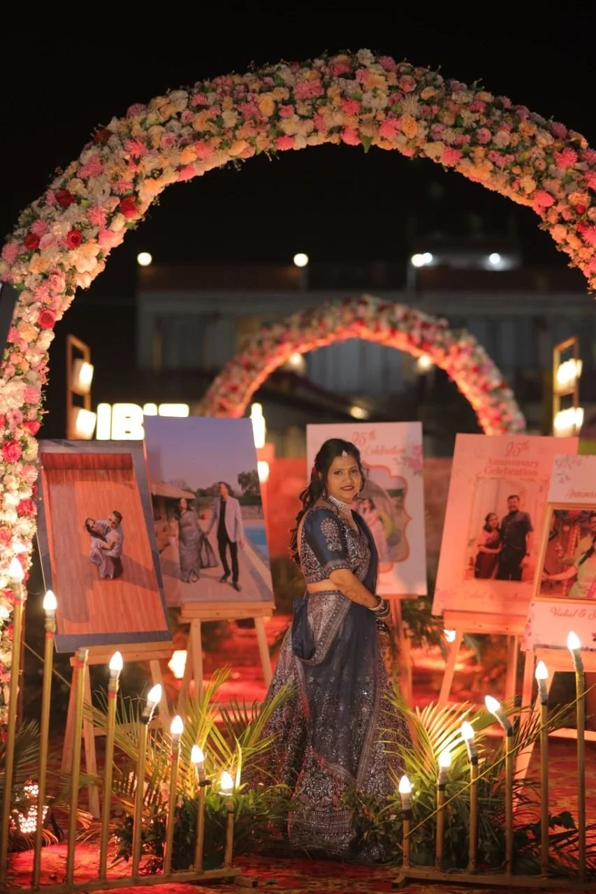 A woman in traditional attire posing inside a decorated floral arch at night, with photo displays and warm lighting. Best farm in Japiur , Private villa with pool in Jaipur, Holiday rental in jaipur, house party villa