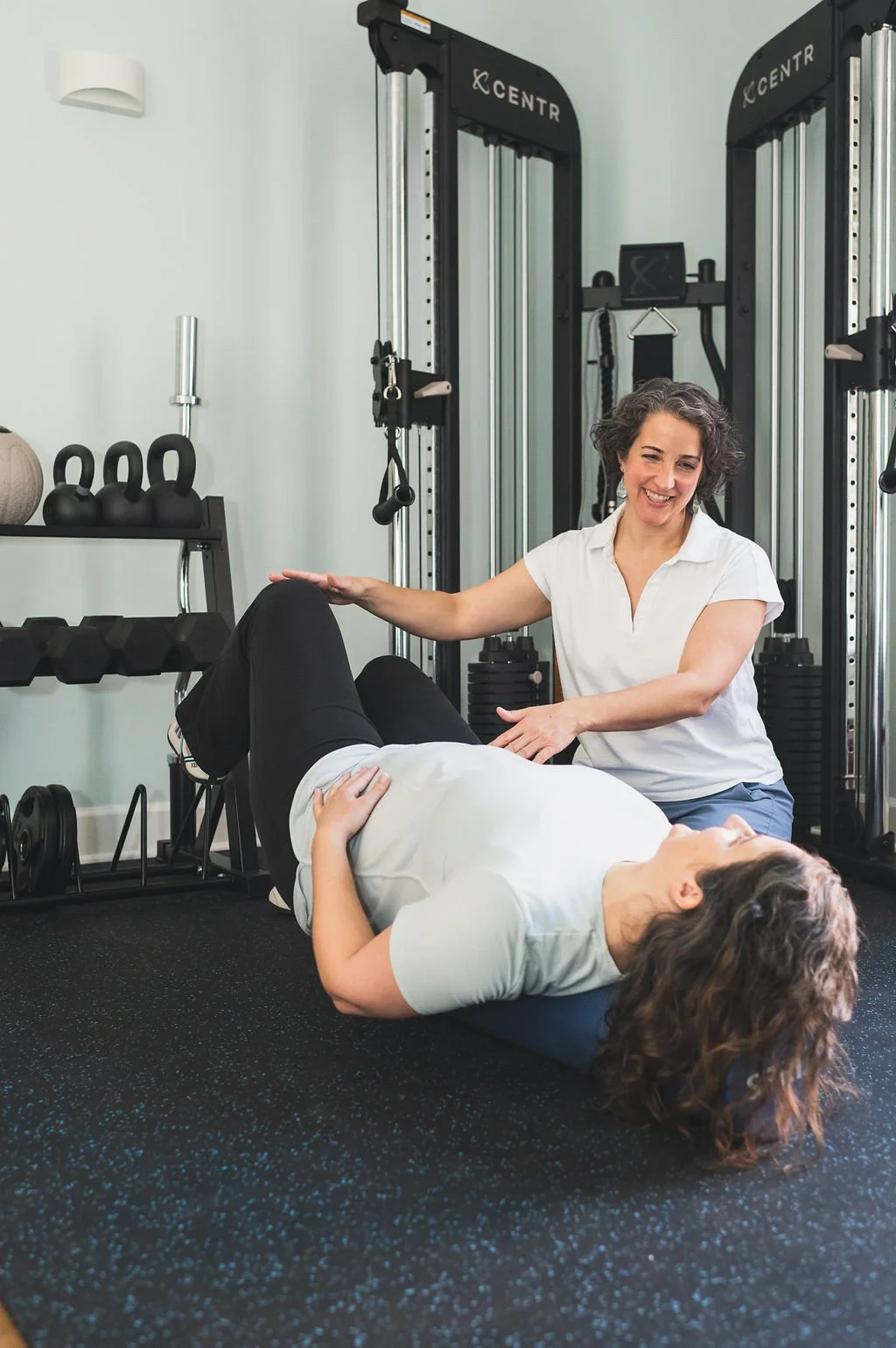 Dr Amanda Shipley is smiling and working with a patient in the gym at Renew Pelvic Health