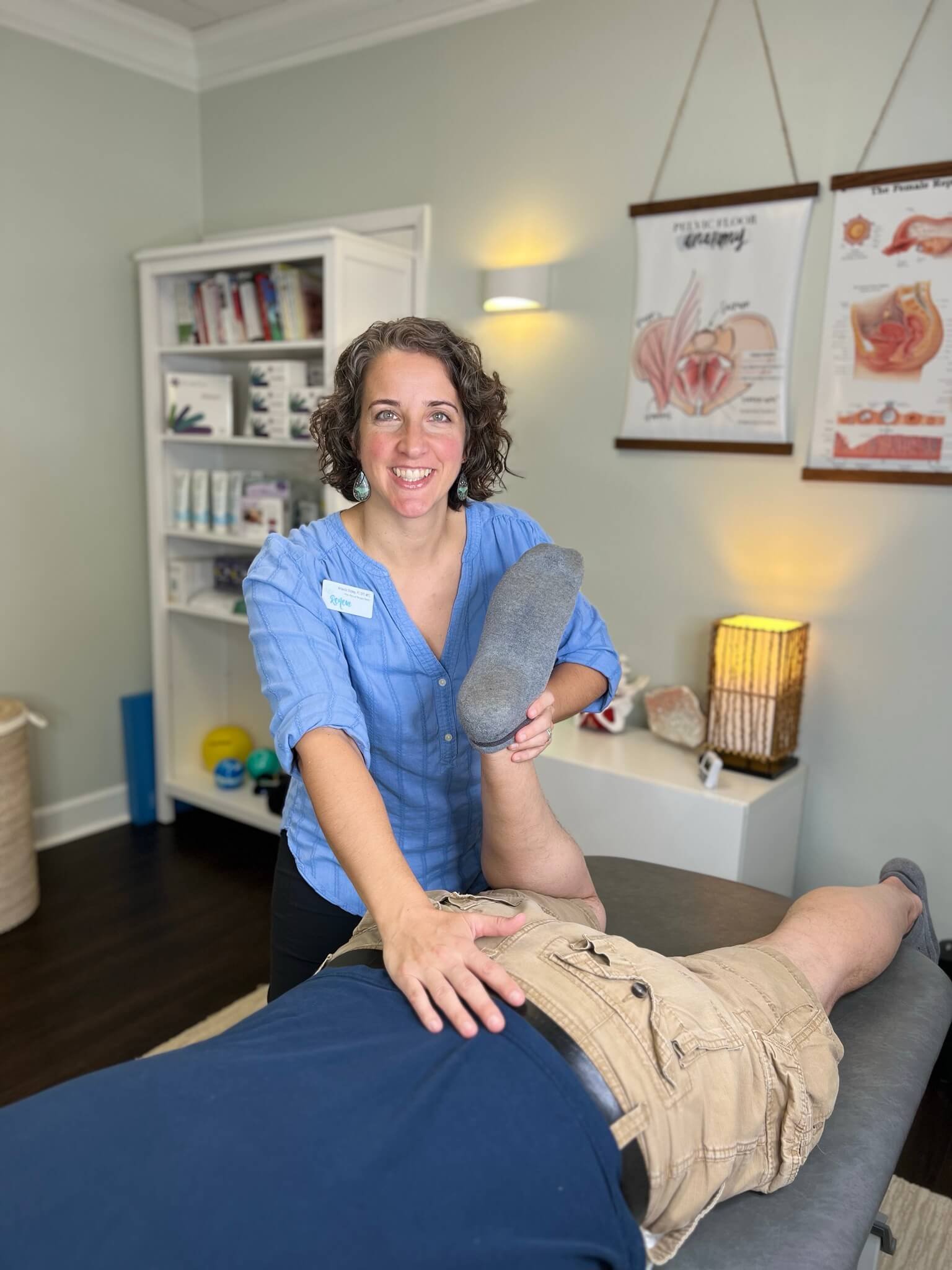 Dr Amanda Shipley helps male patient with lower body stretch in pelvic floor therapy visit
