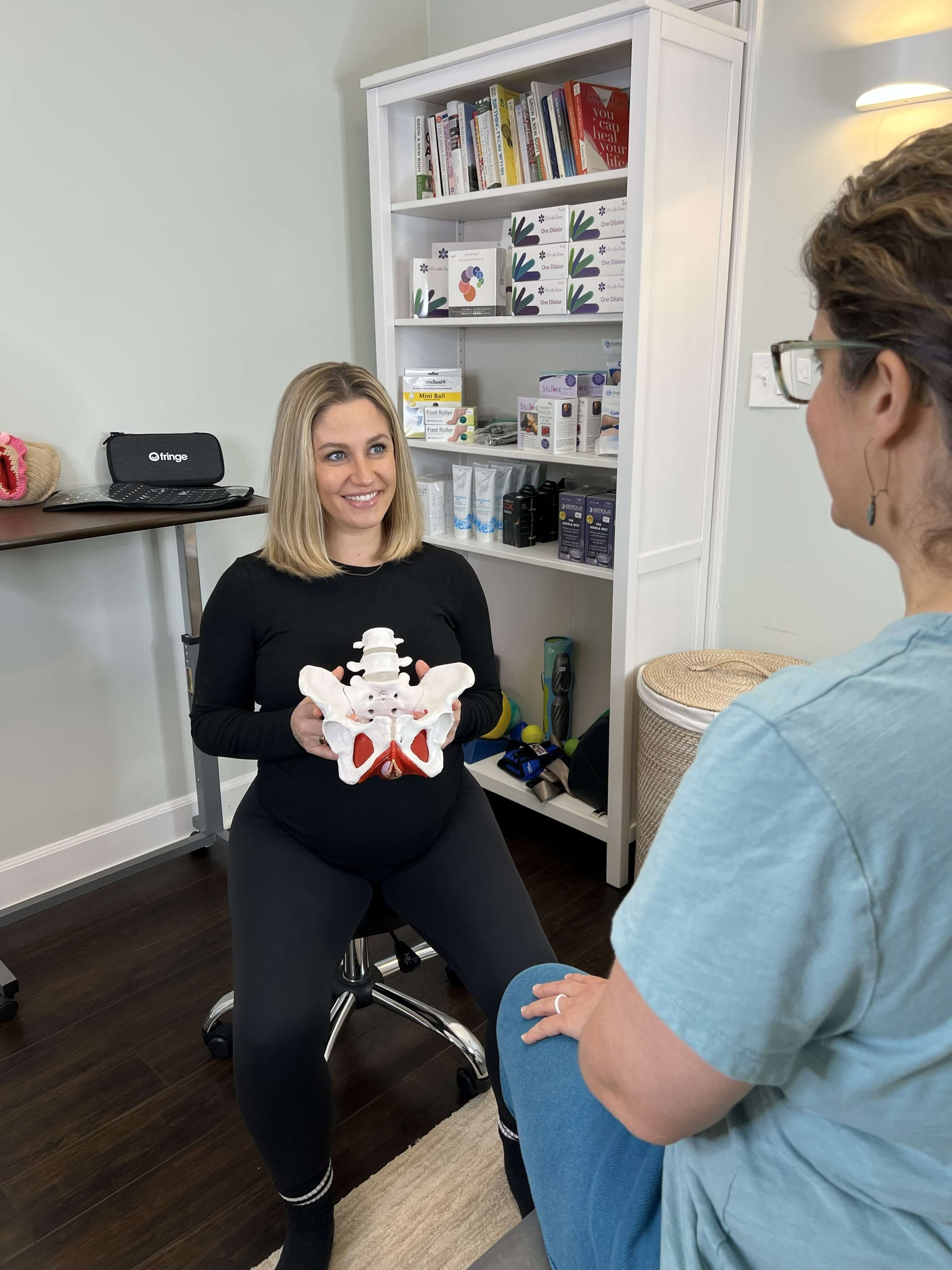 Dr Ashley Zimmerman shows a pelvic floor model to a patient in a treatment room at Renew Pelvic Health in Atlanta GA