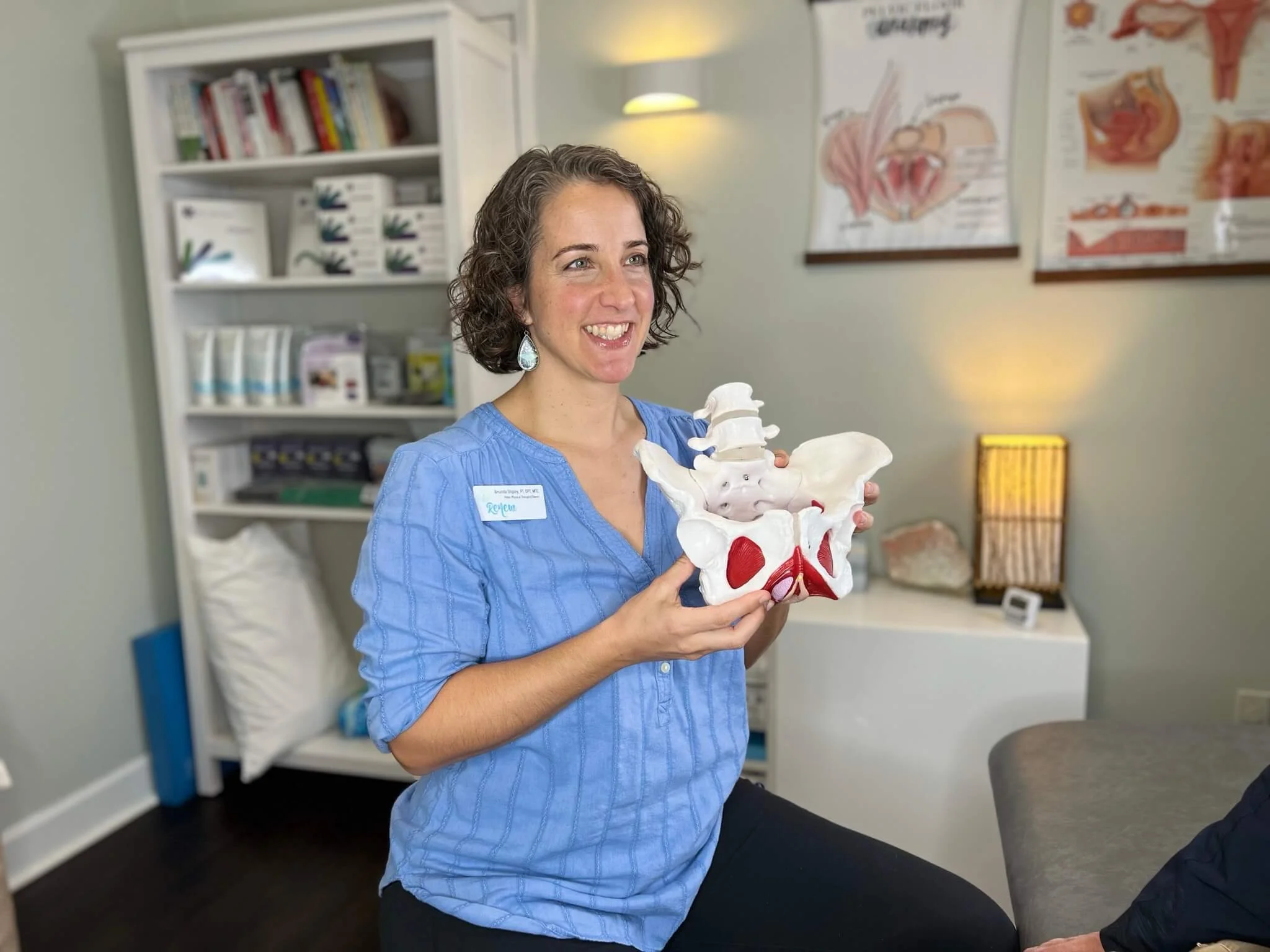 Dr Amanda Shipley holds a pelvic model in a treatment room at Renew Pelvic Health