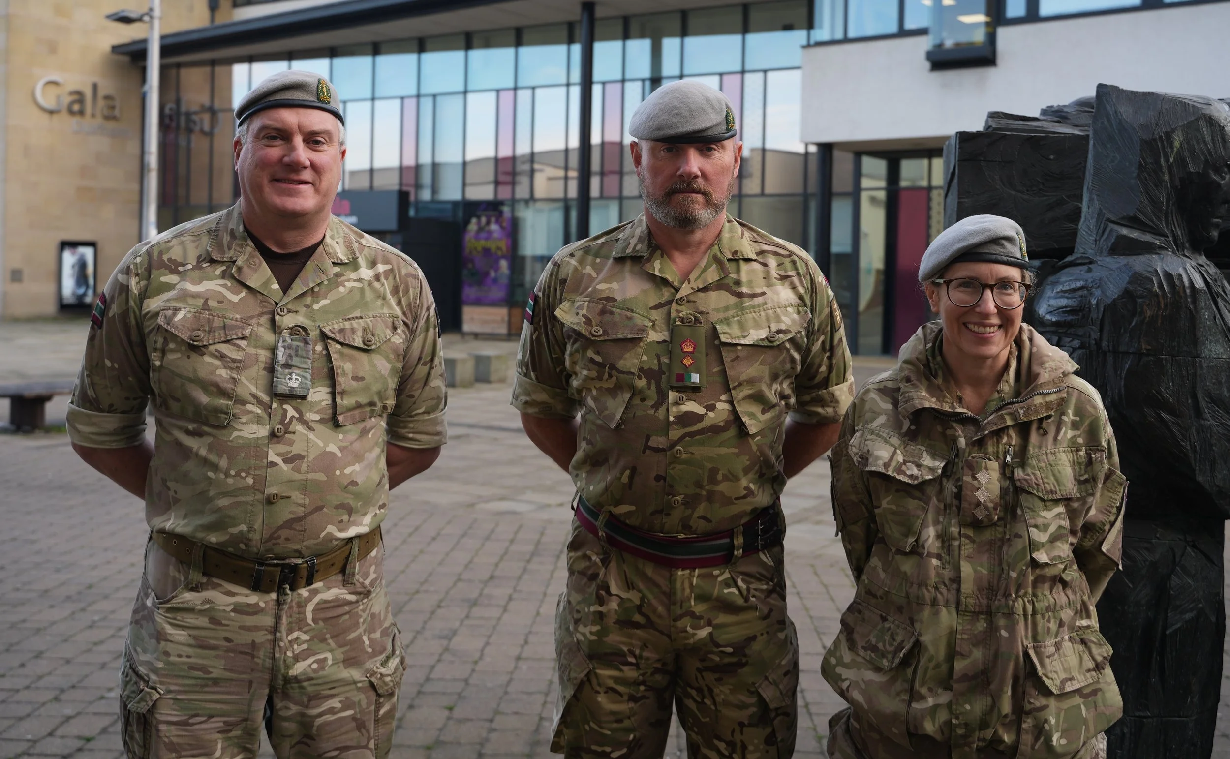 Three soldiers in camouflage dress standing outside Clayport Library
