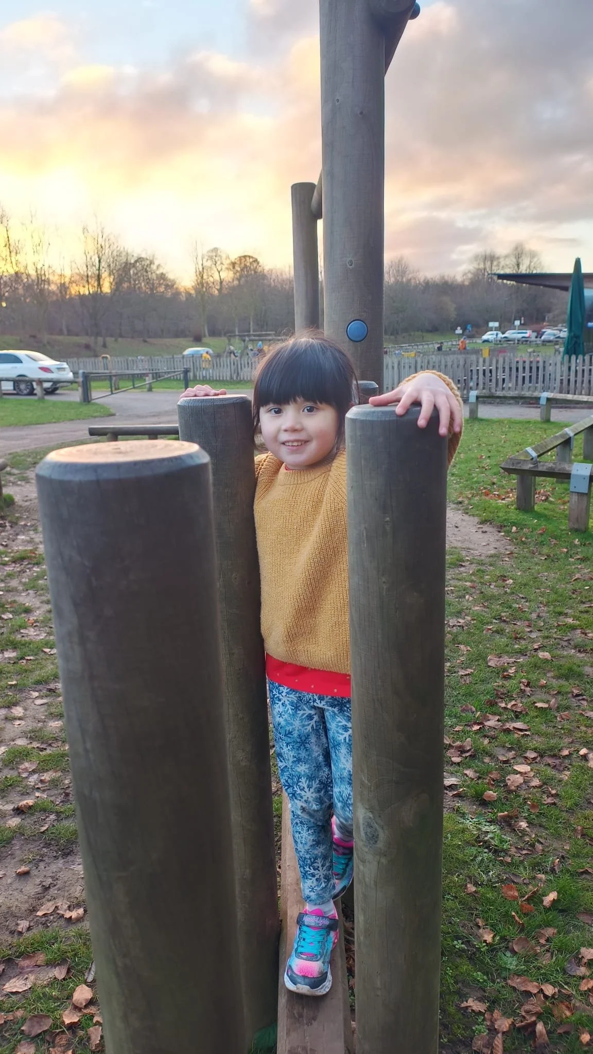 .Child balancing between wooden posts in the play area at Hardwick Park near Durham.